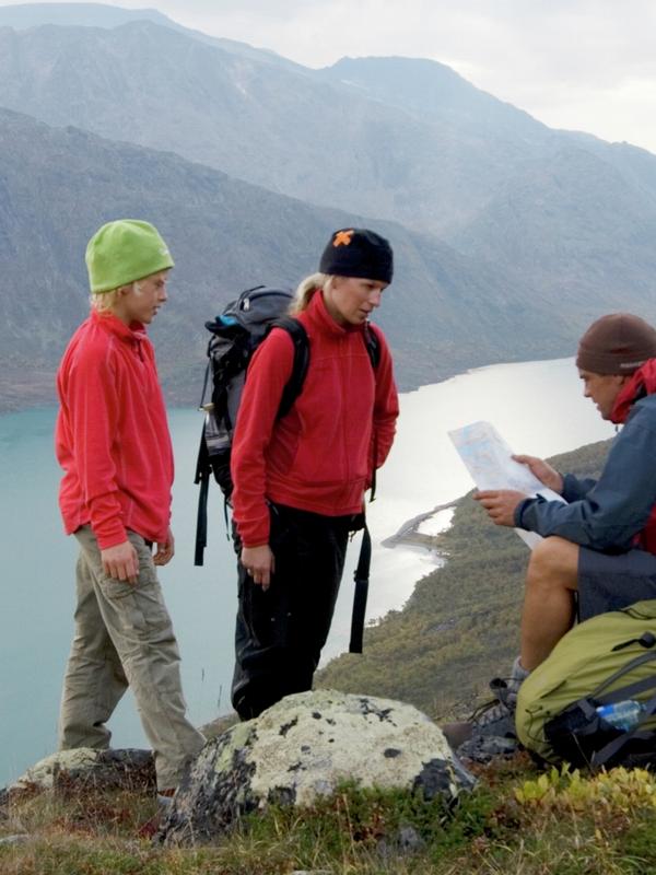 En familie leser kart i Jotunheimen
