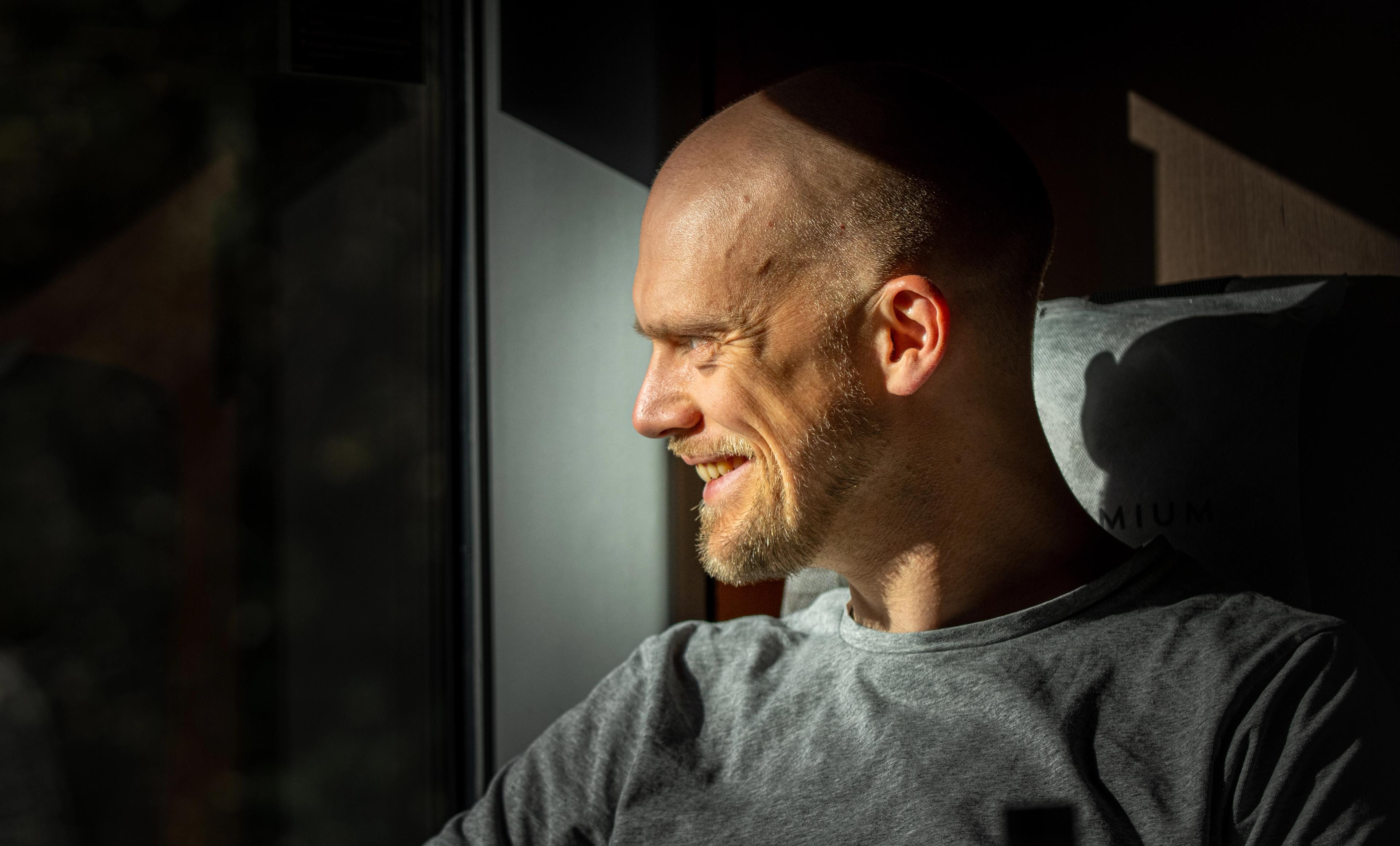 A man sitting in the seat at the Dovre Railway train