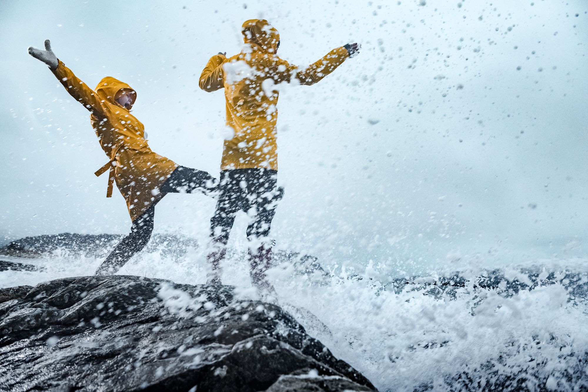 Two people playing in the storm in Kalvåg, Fjord Norway