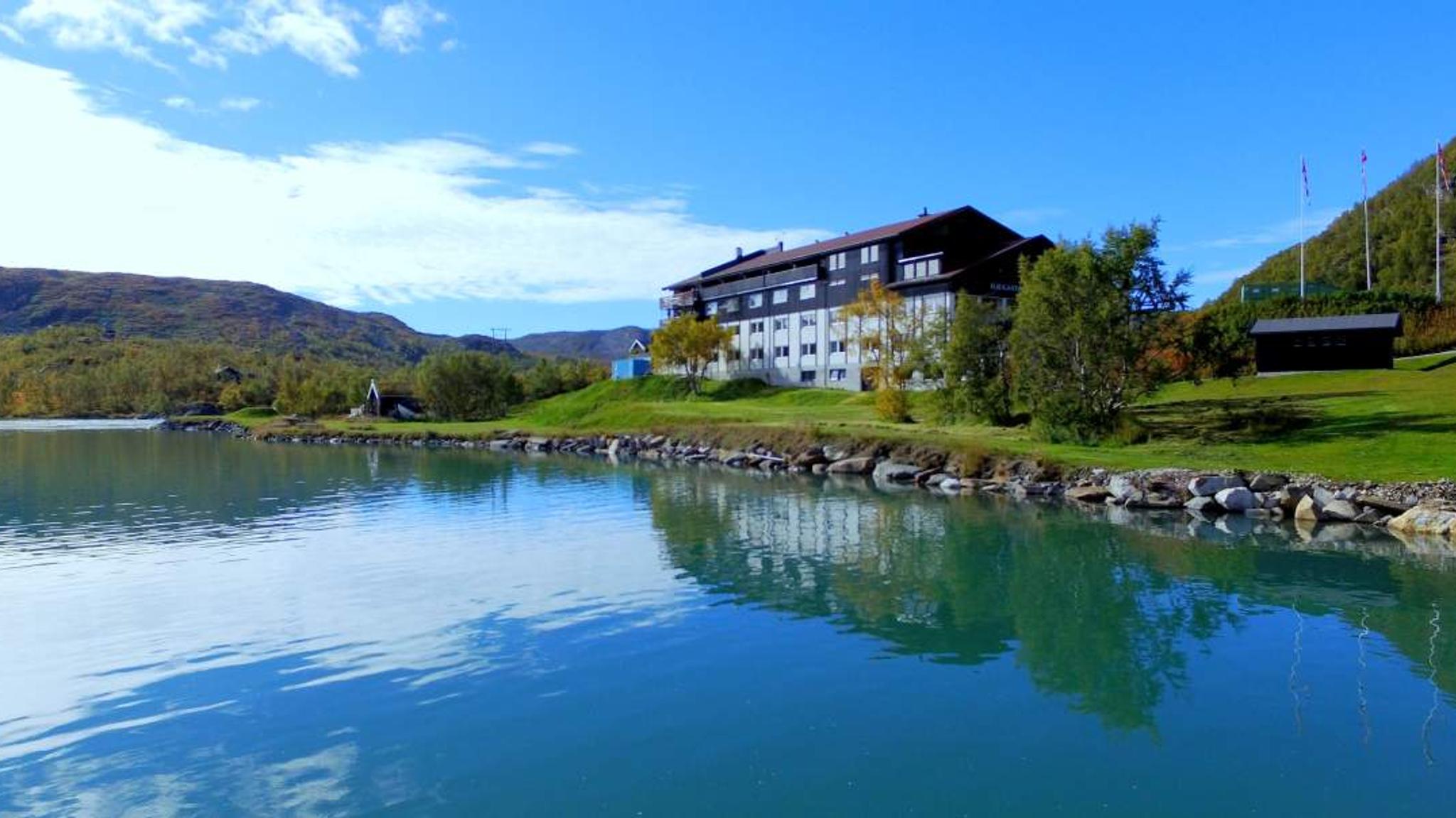 A large wooden house by a lake.
