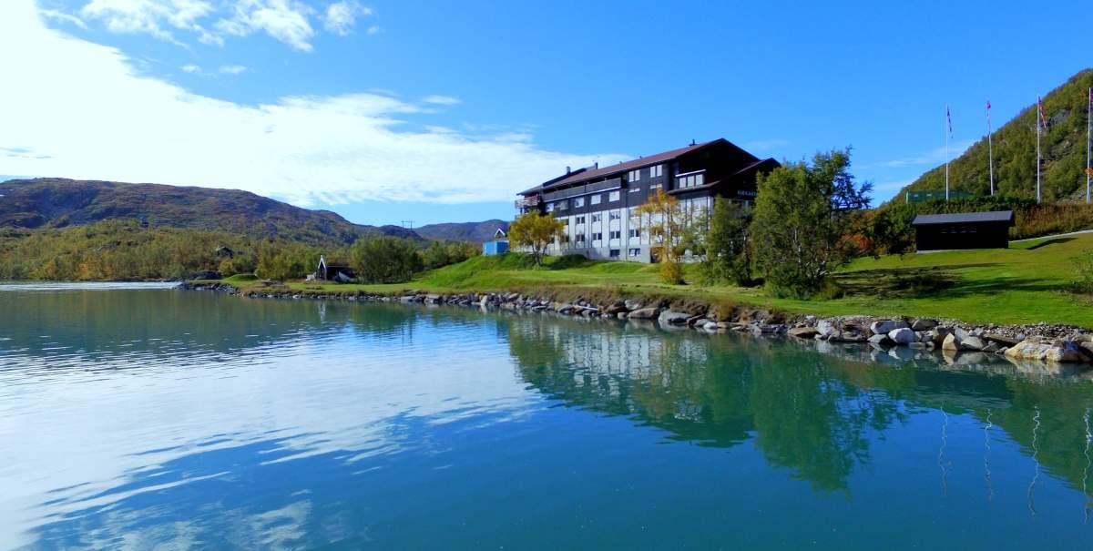A large wooden house by a lake.