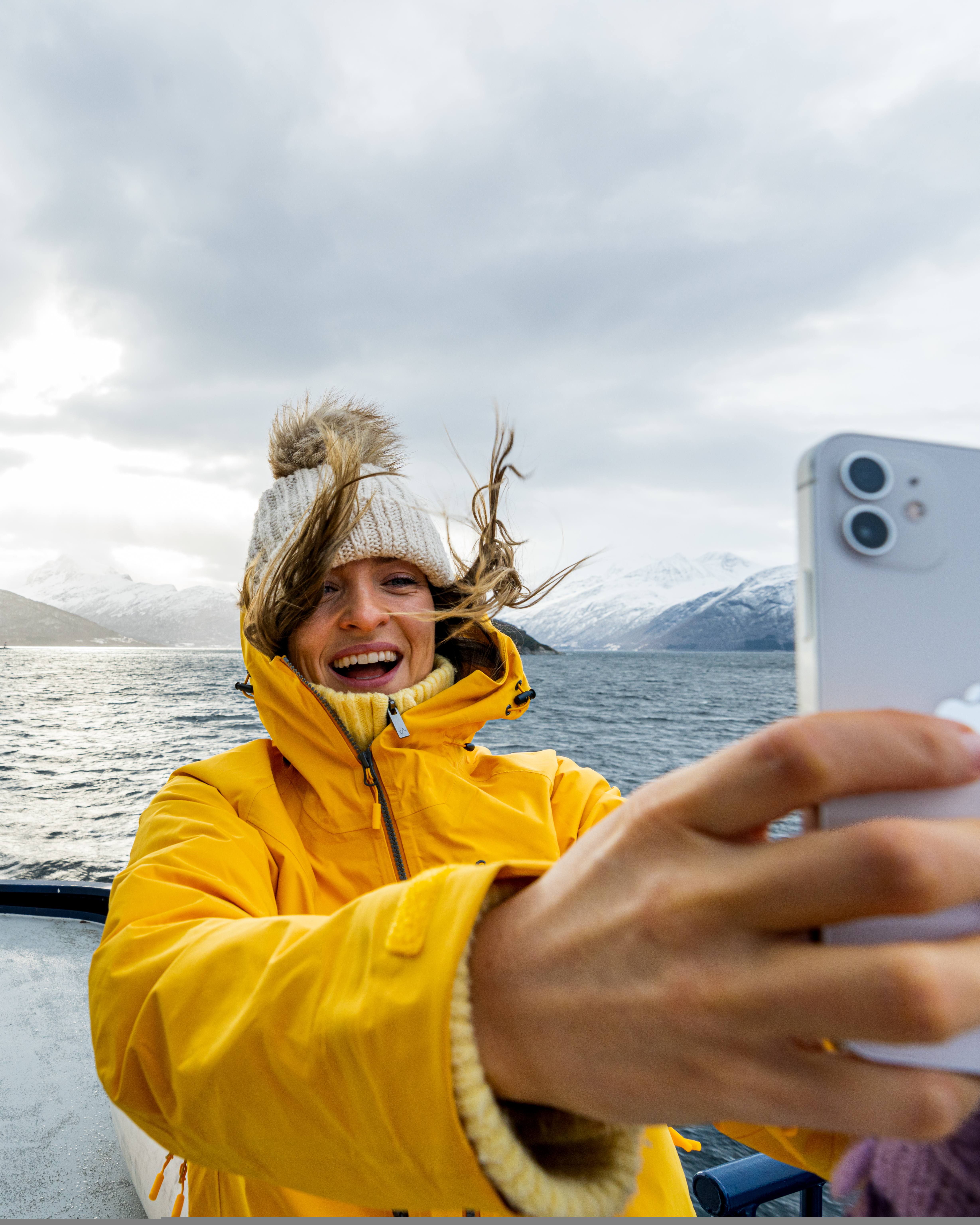 Woman taking a selfie on a winter cruise on the Geirangerfjord