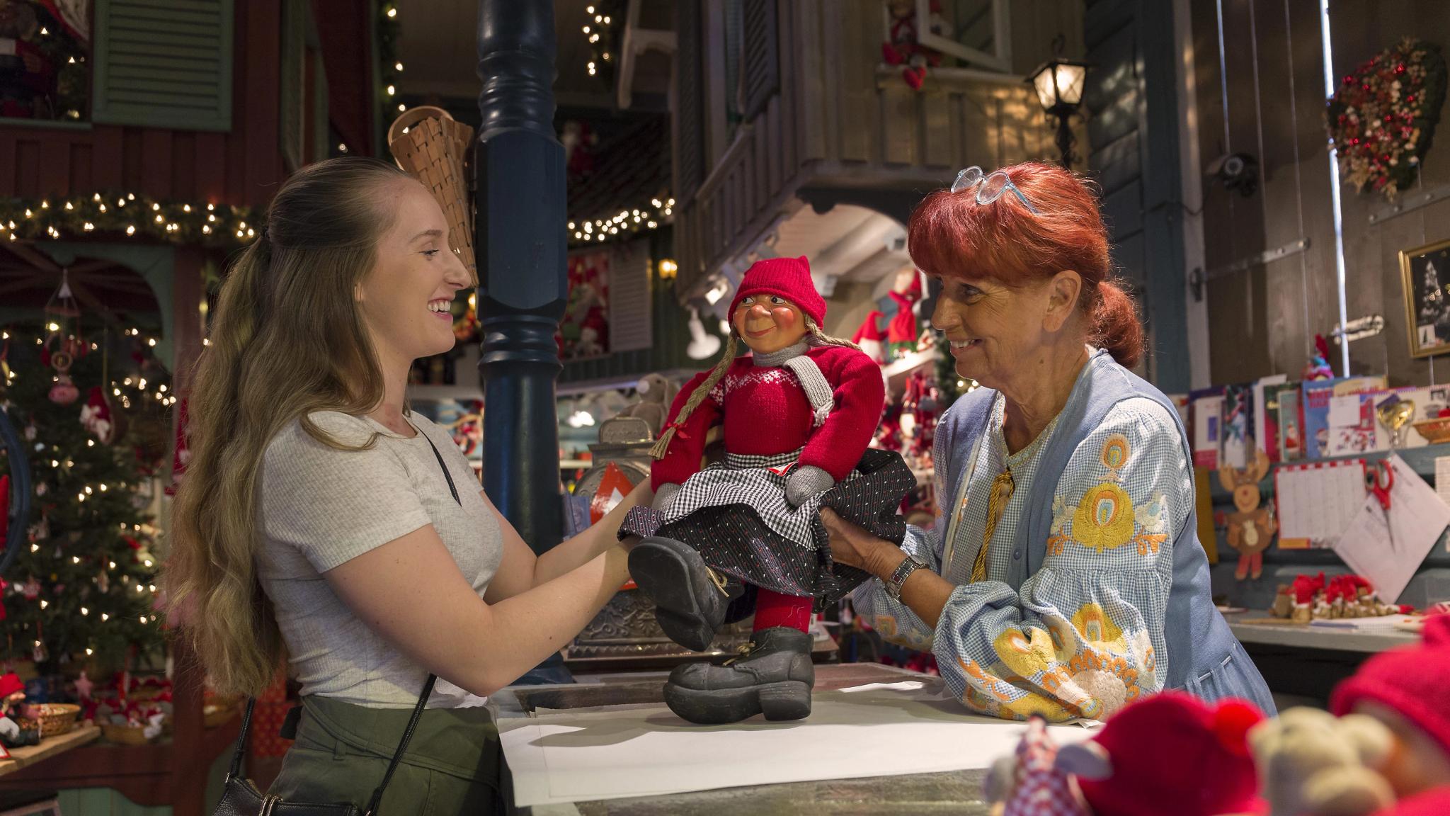 A woman is buying Christmas decorations in the shop Tregaardens julehus during summer in Drøbak, Eastern Norway