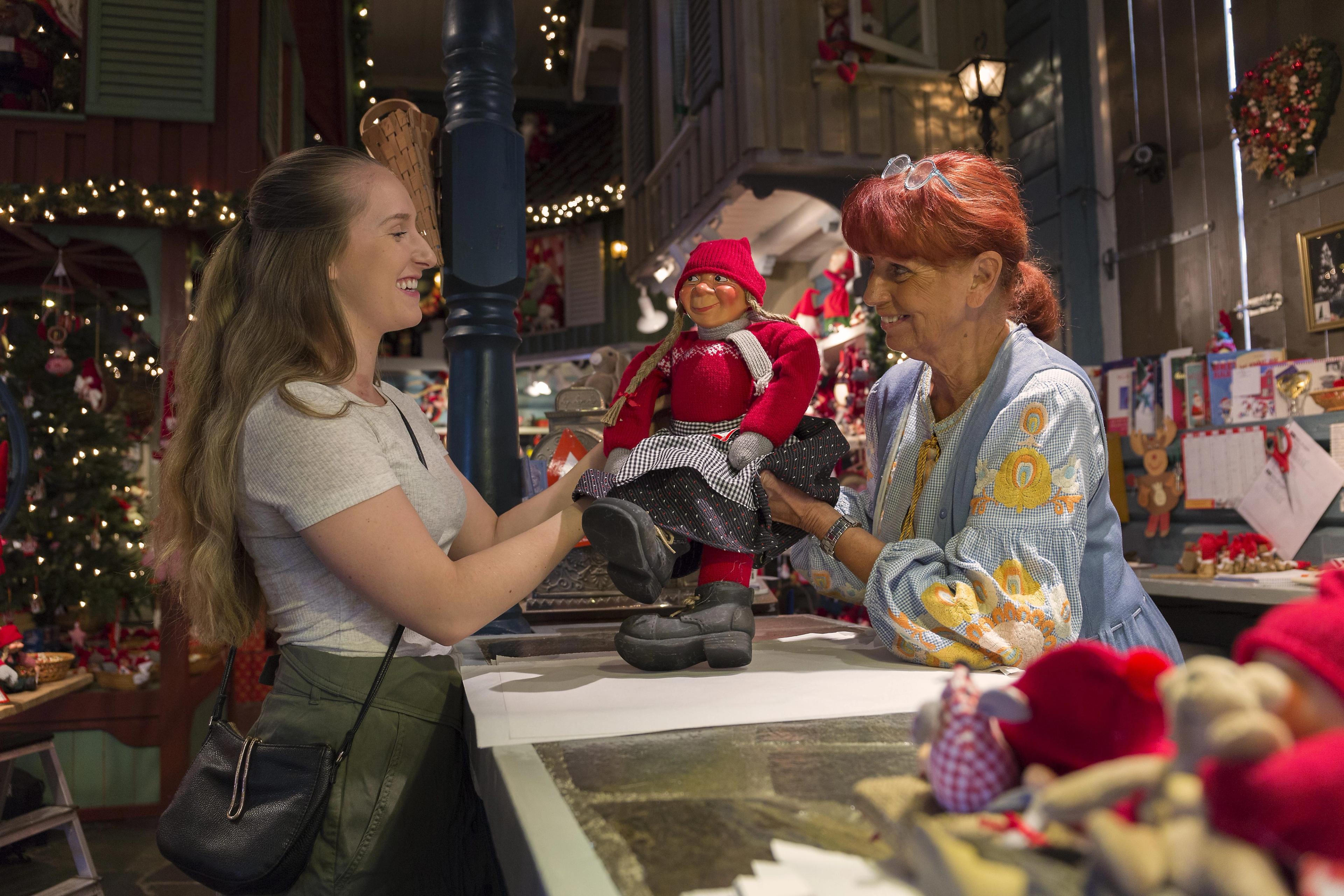 A woman is buying Christmas decorations in the shop Tregaardens julehus during summer in Drøbak, Eastern Norway