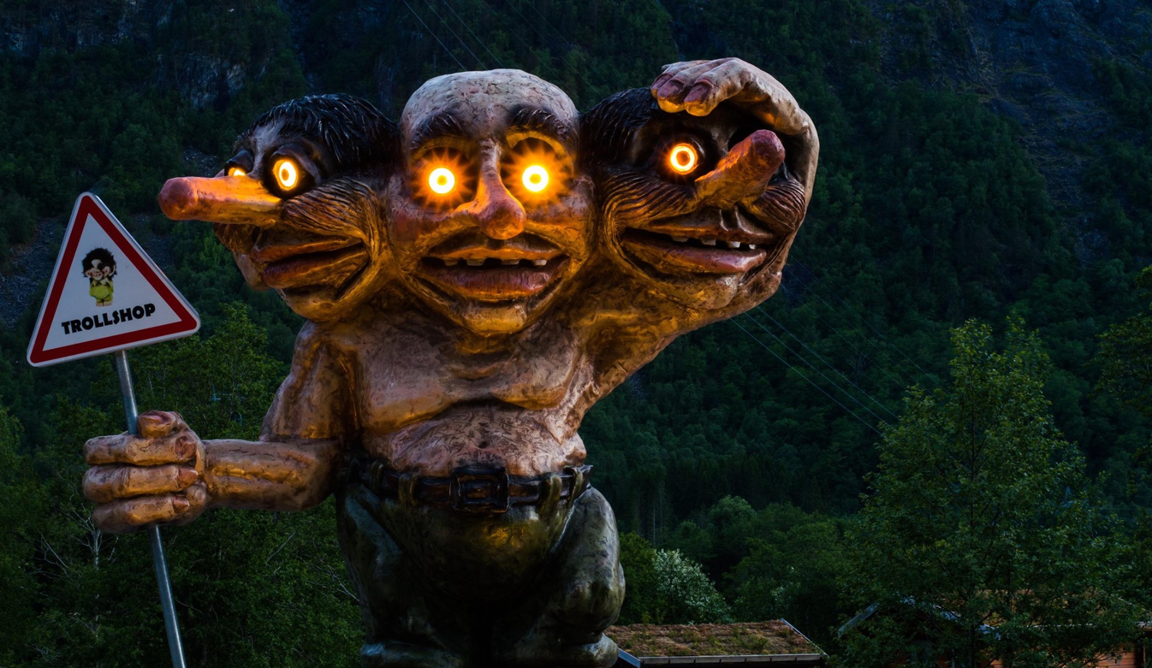 A statue of a three headed troll with lights in the eyes