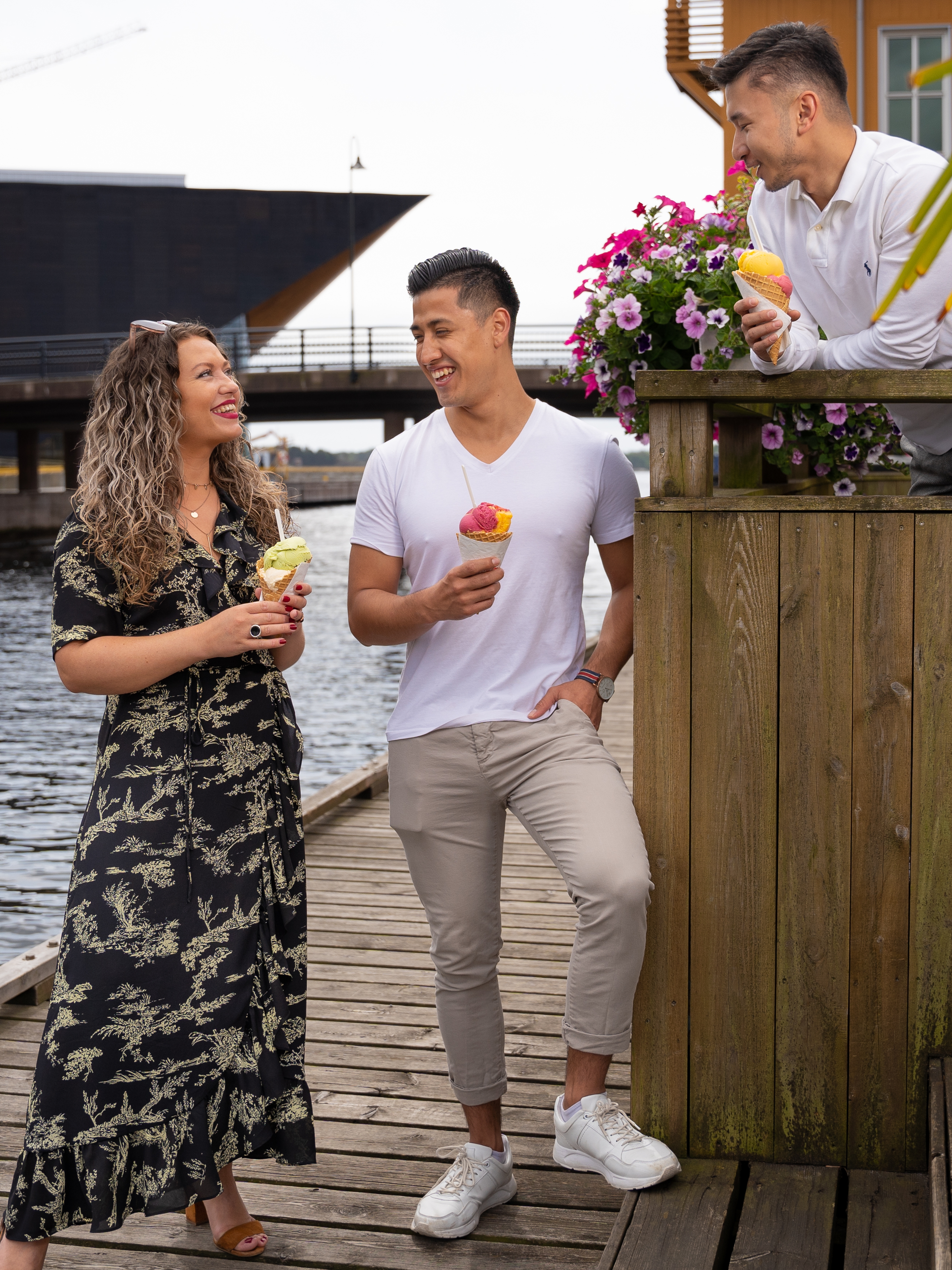 Tre personer spiser is på bryggekanten i Kristiansand på Sørlandet