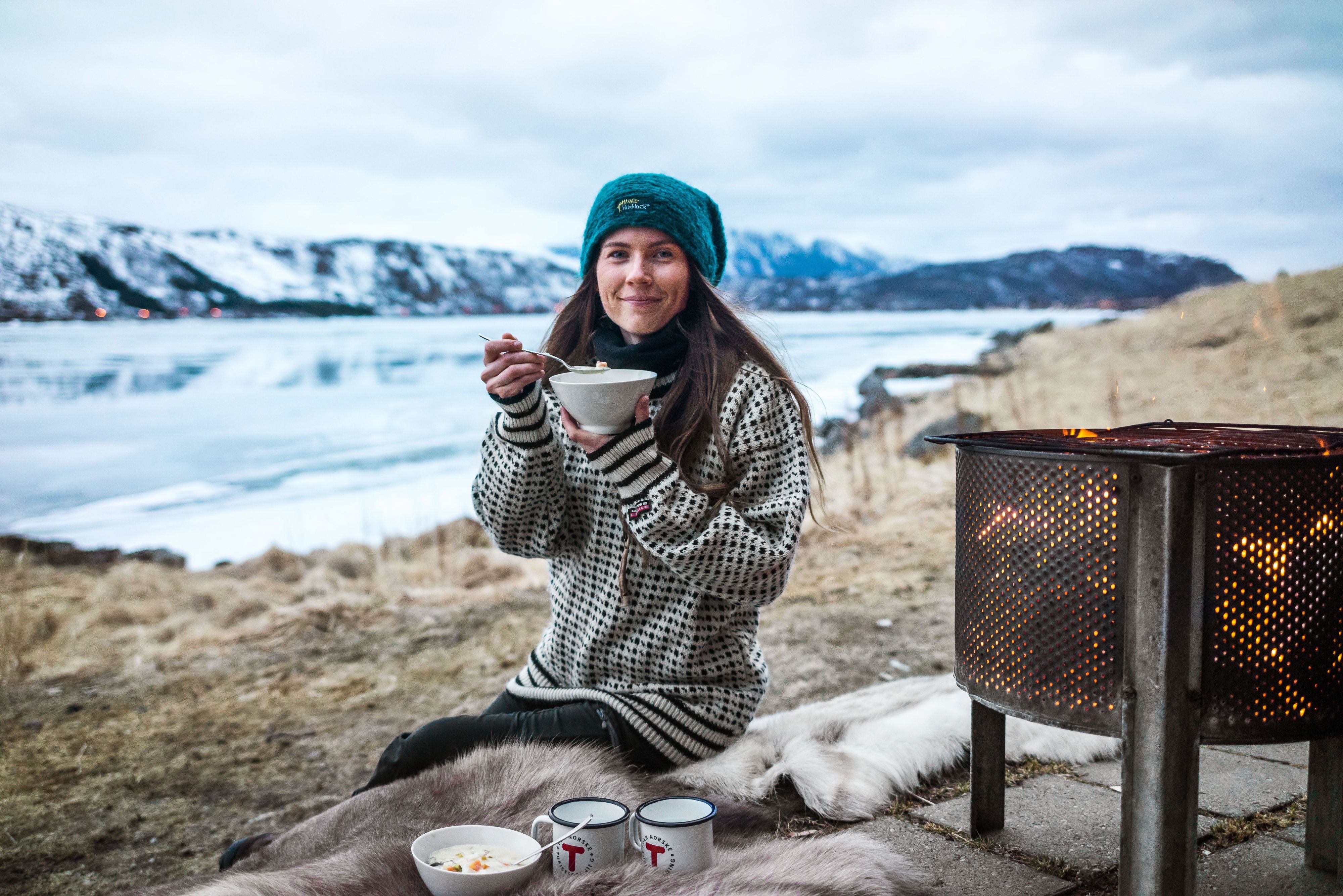 A woman eating fish soup in the nature