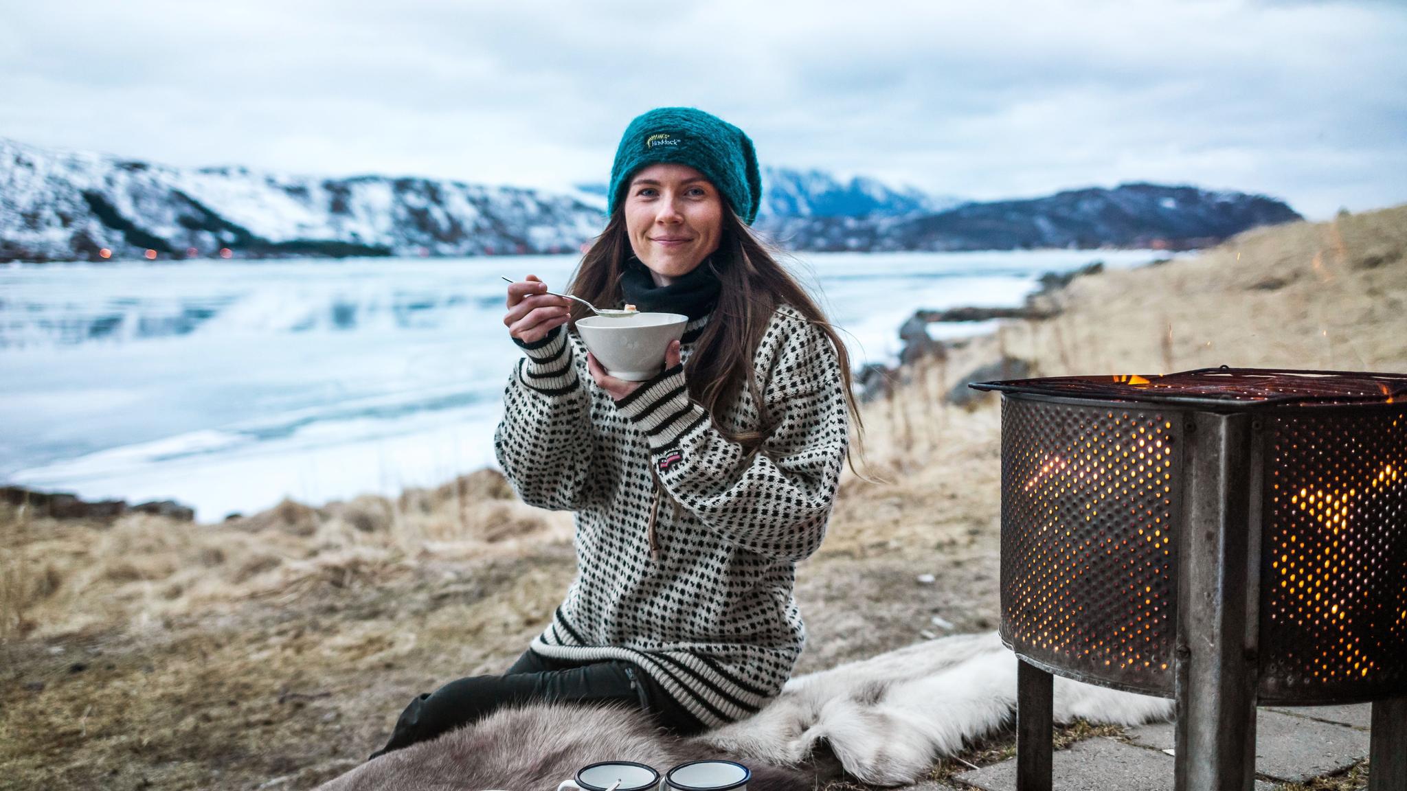 A woman eating fish soup in the nature