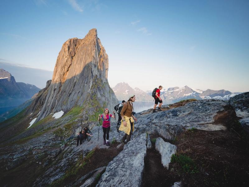 People hiking up a steep mountain with beautiful views.