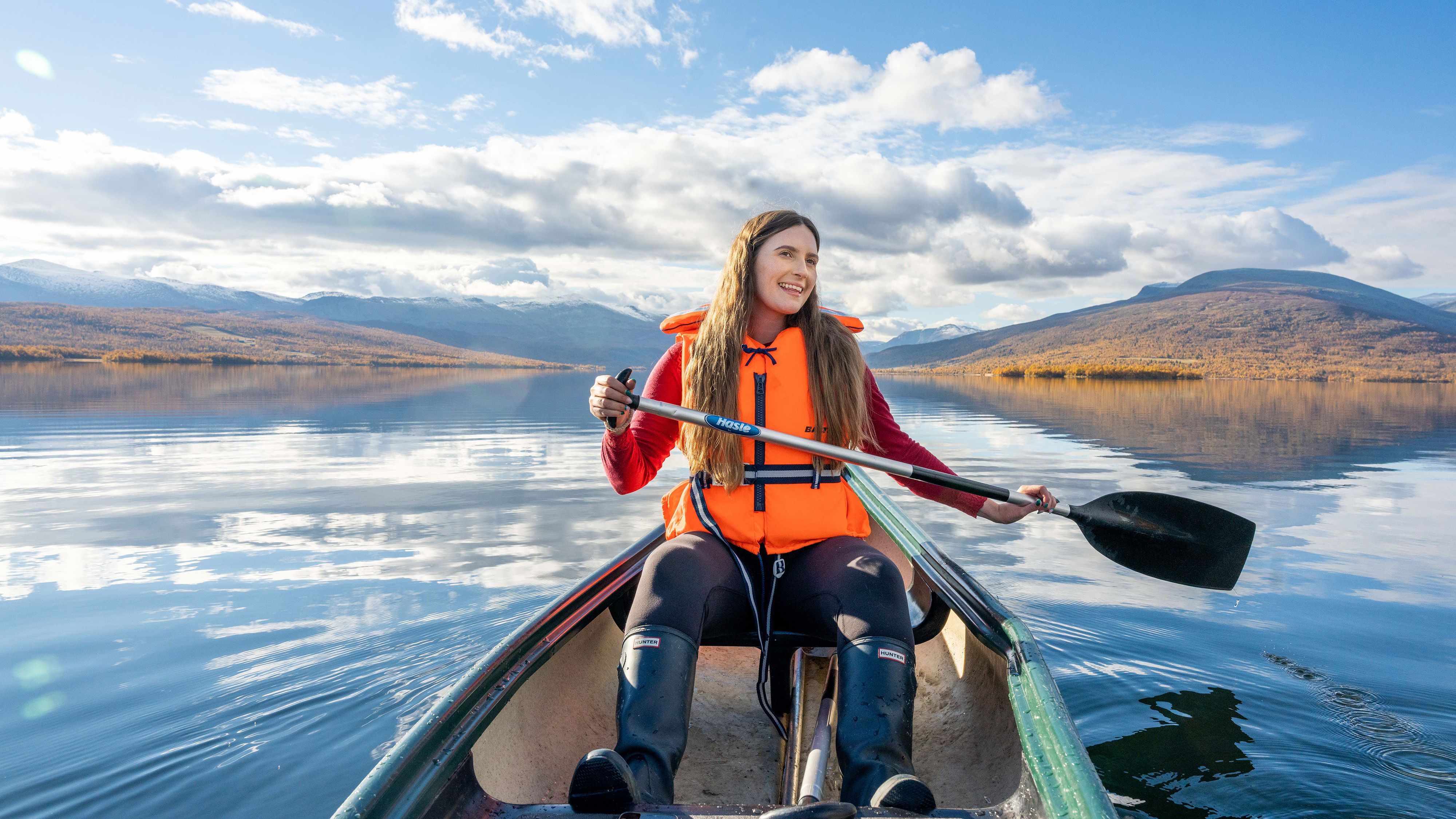 A woman canoeing in a lake by Nøsen yoga and mountain hotel in Eastern Norway
