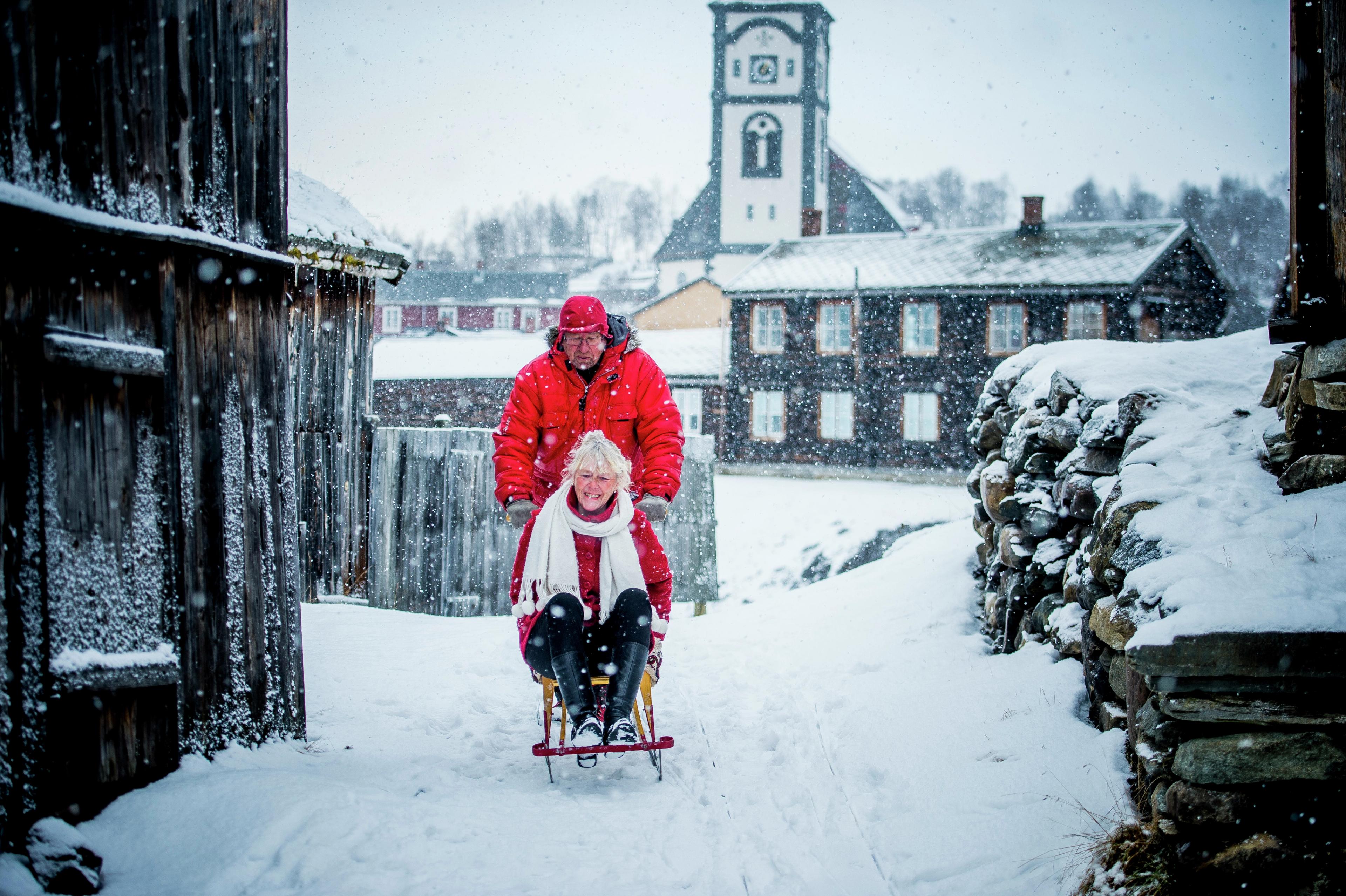 Two people on a kicksled in the snowy centre of Røros, Trøndelag, Norway