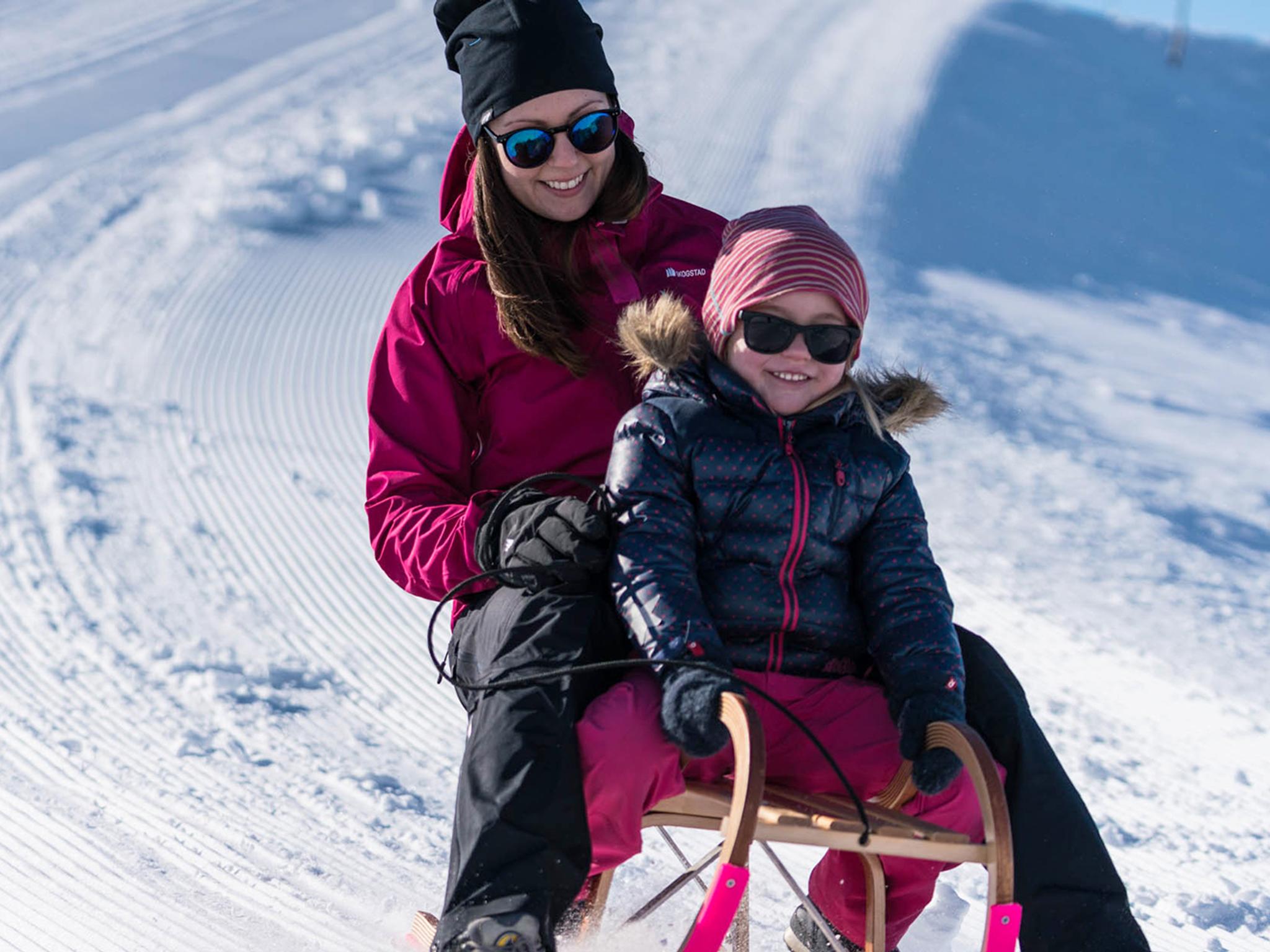 Mutter und Tochter beim Schlittenfahren am Berg Hofen beim Loen Skylift in Norwegen