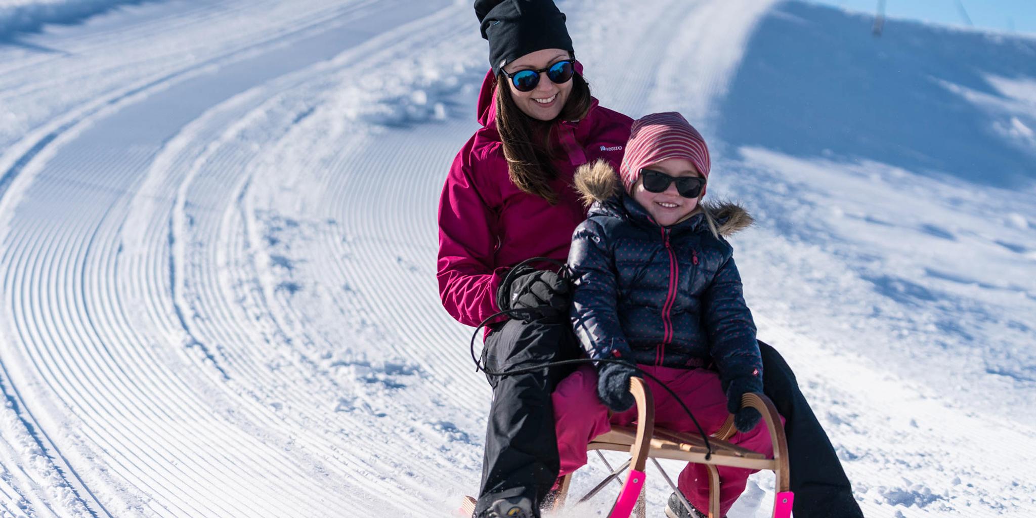 Mother and daughter tobogganing at Mount Hoven by the Loen Skylift in Loen, Fjord Norway