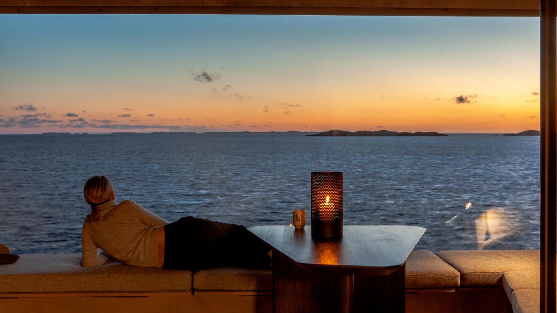 Woman enjoying the view from one of the Floke cabins in Haugesund