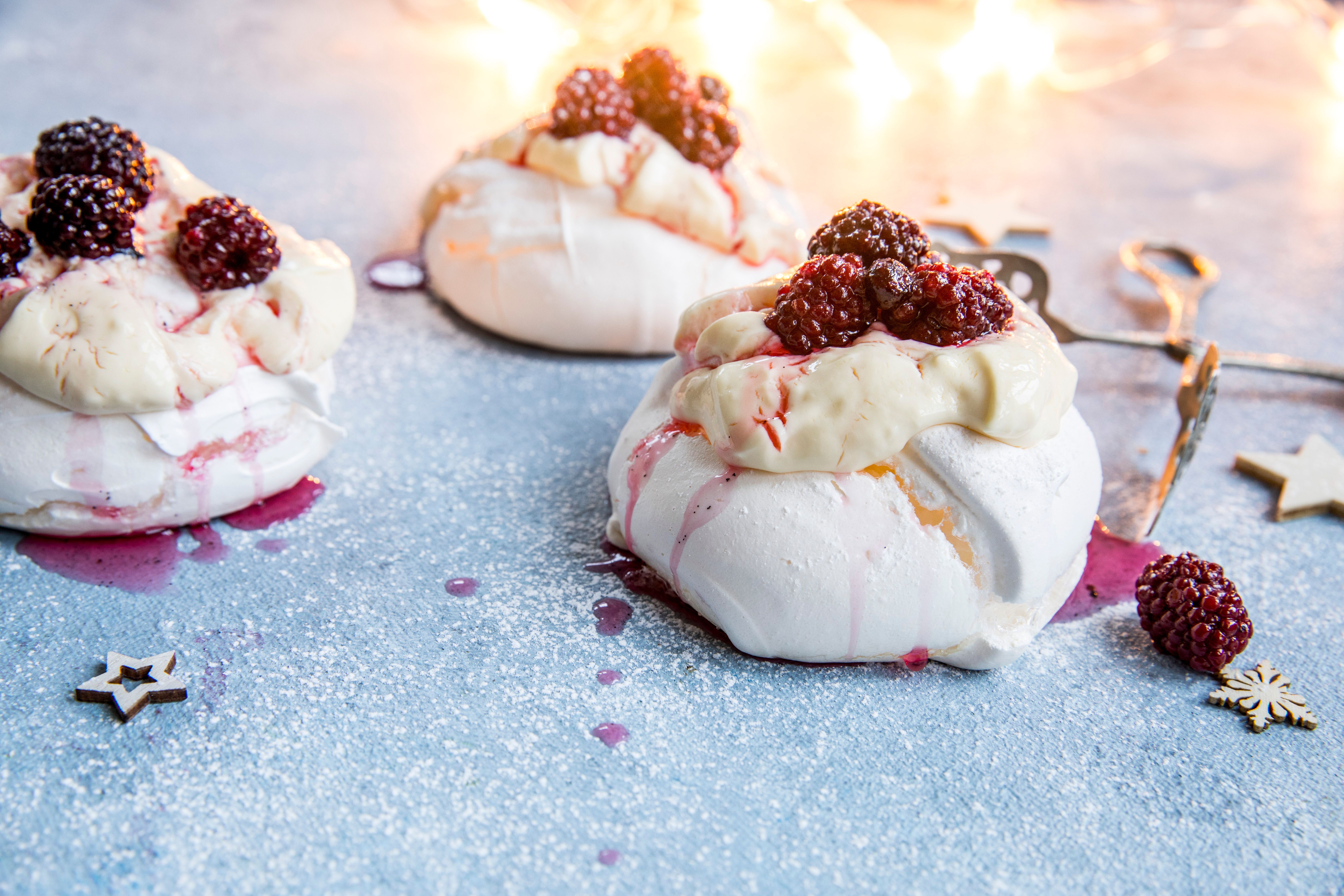 Three mini pavlovas with cream and blackberries