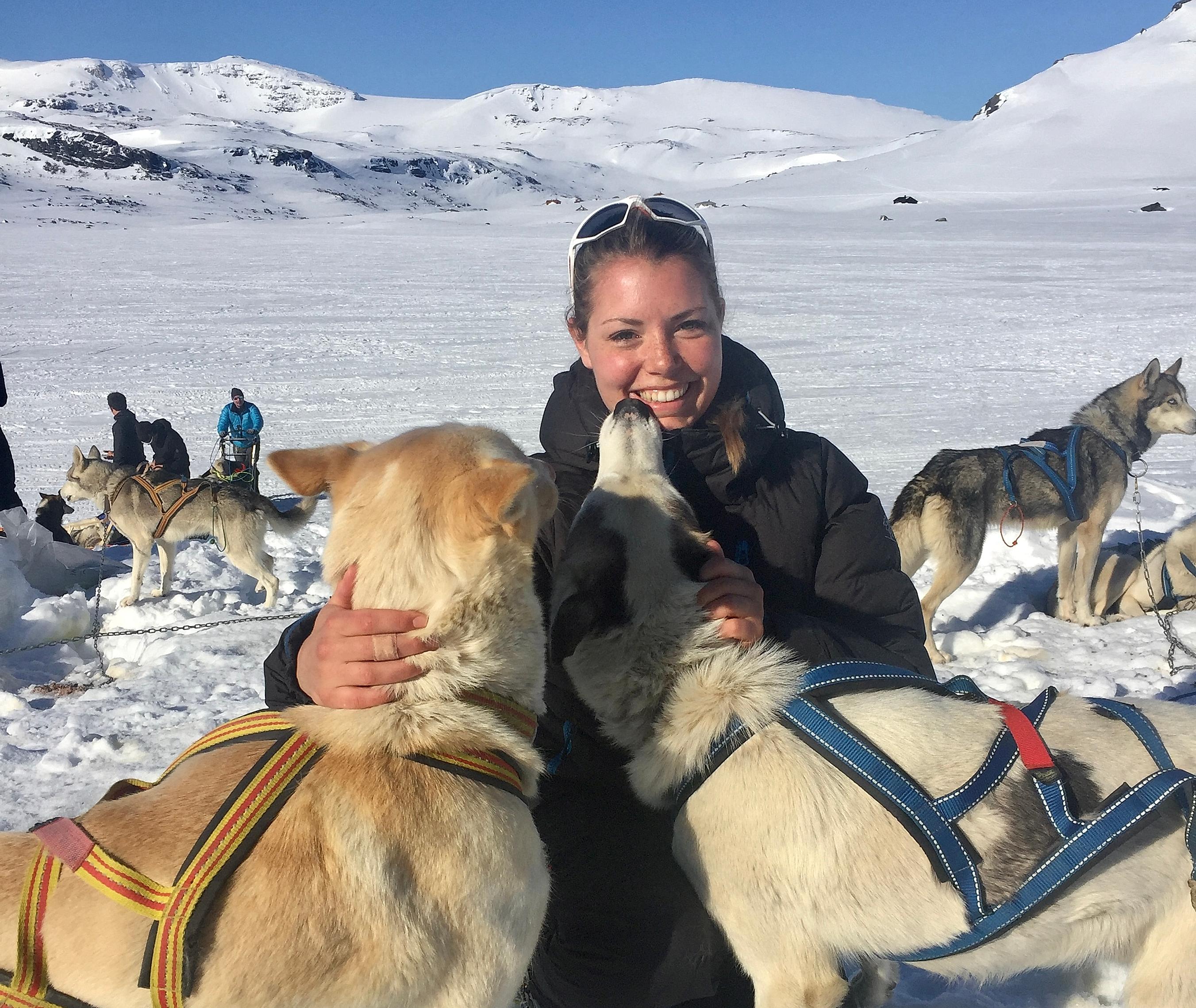 Woman petting the huskies before dog sledding at Finse