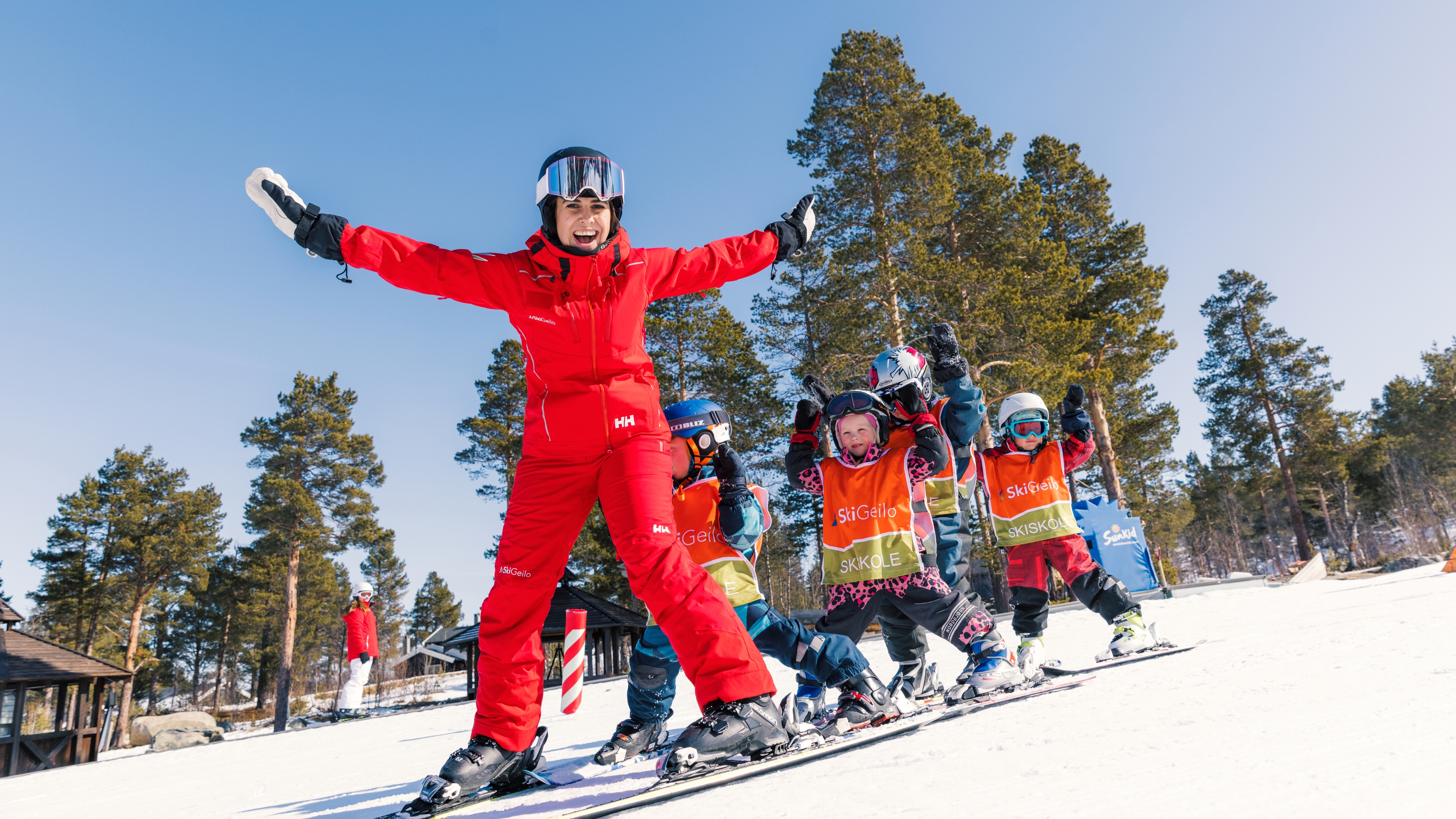 Ski instructor smiling with young students behind her