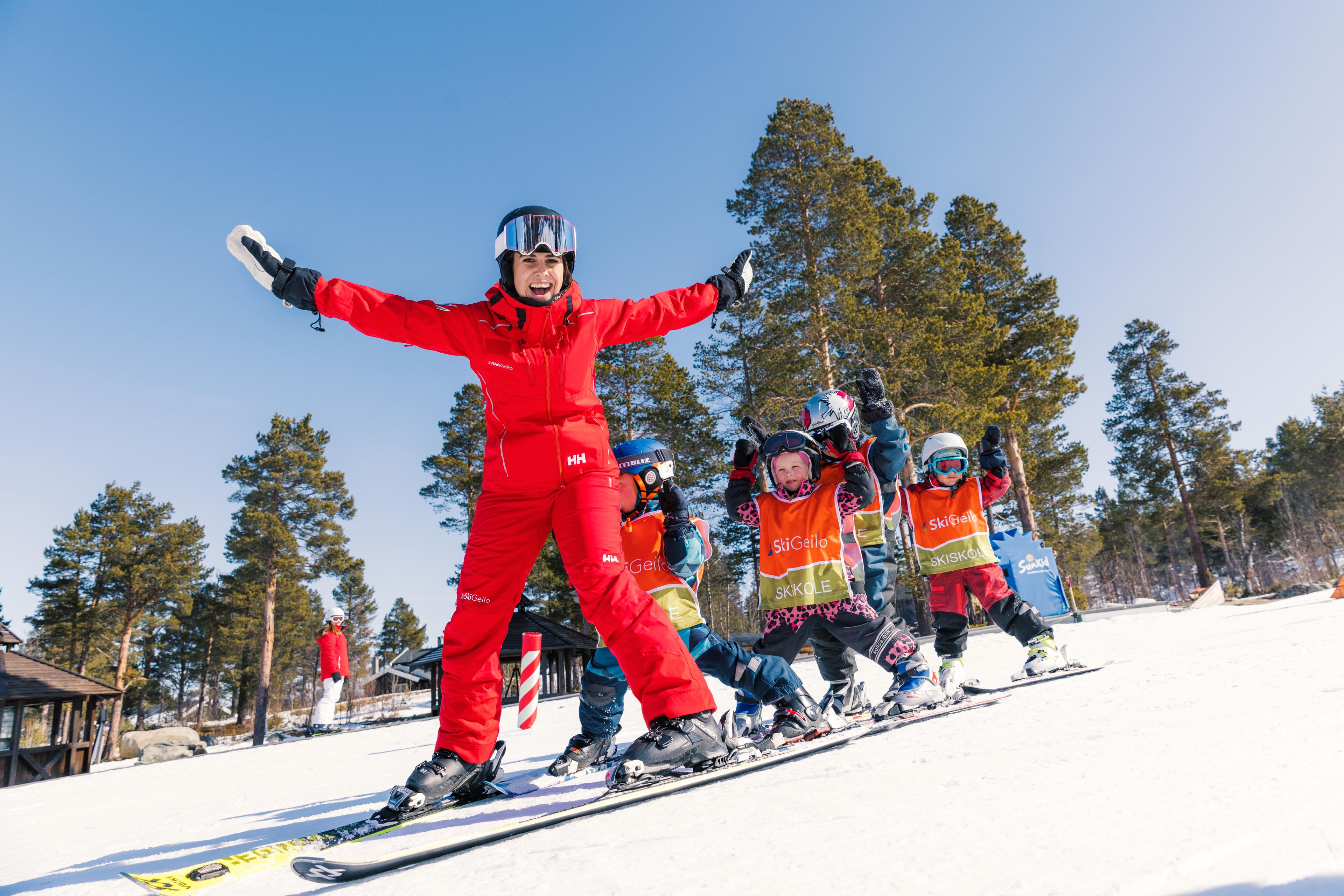 Ski instructor smiling with young students behind her