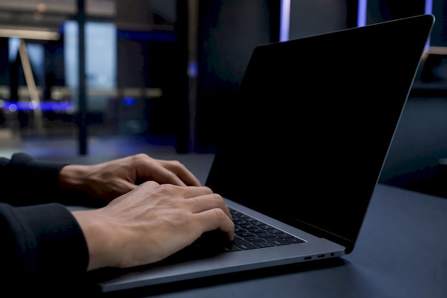 Hands poised over laptop keyboard with screen off
