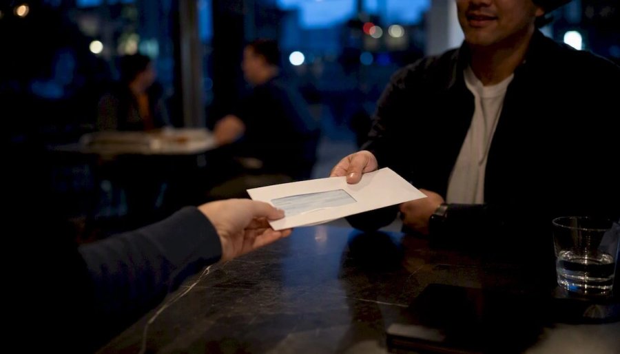 Hands delivering first paycheck