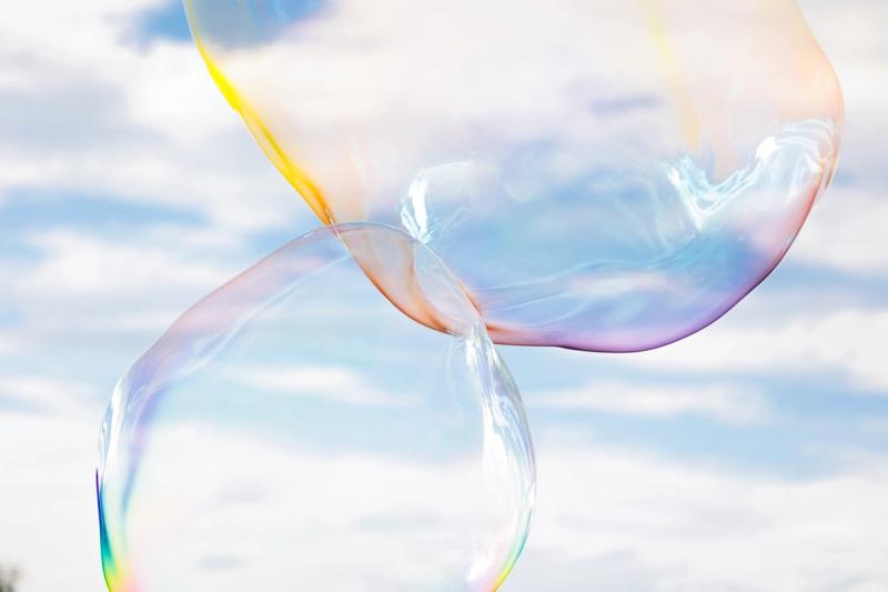 藍天白雲下，兩顆透明的大泡泡輕輕相觸