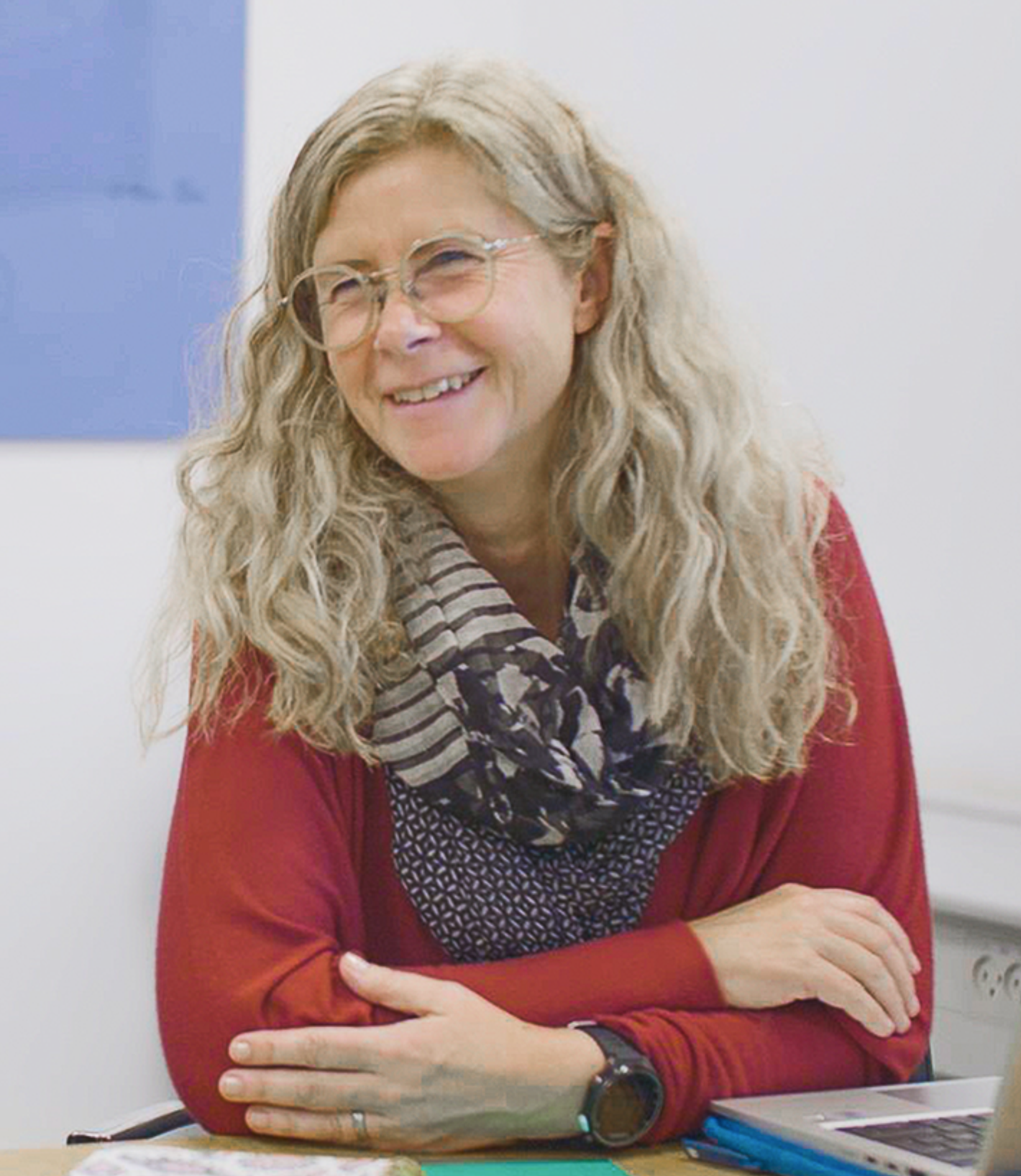 Madeline Lundgren - smiling woman with long grey hair, red top with scarf