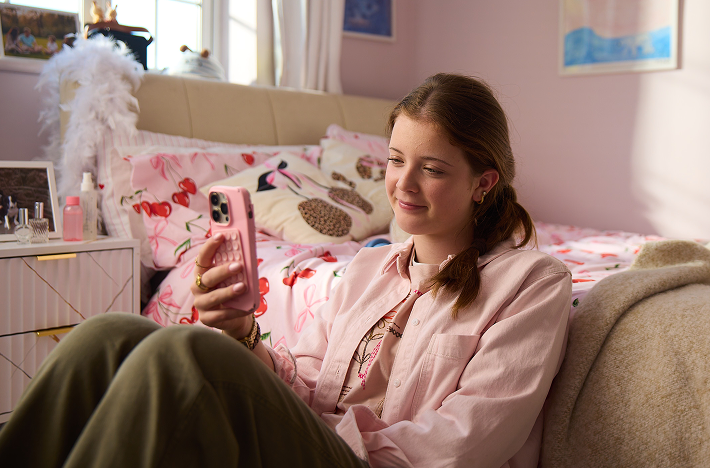 A young woman relaxing at home looking at her phone