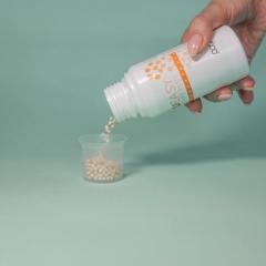 HCU Easy Microtabs Plus bottle pouring microtabs into measuring cup