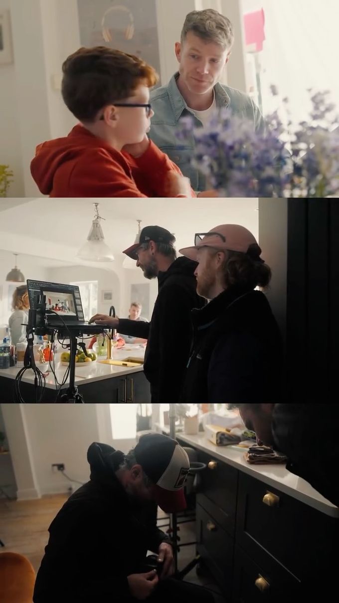 Behind the scenes of a film shoot: a boy in a red hoodie with a man, and a crew filming in a kitchen