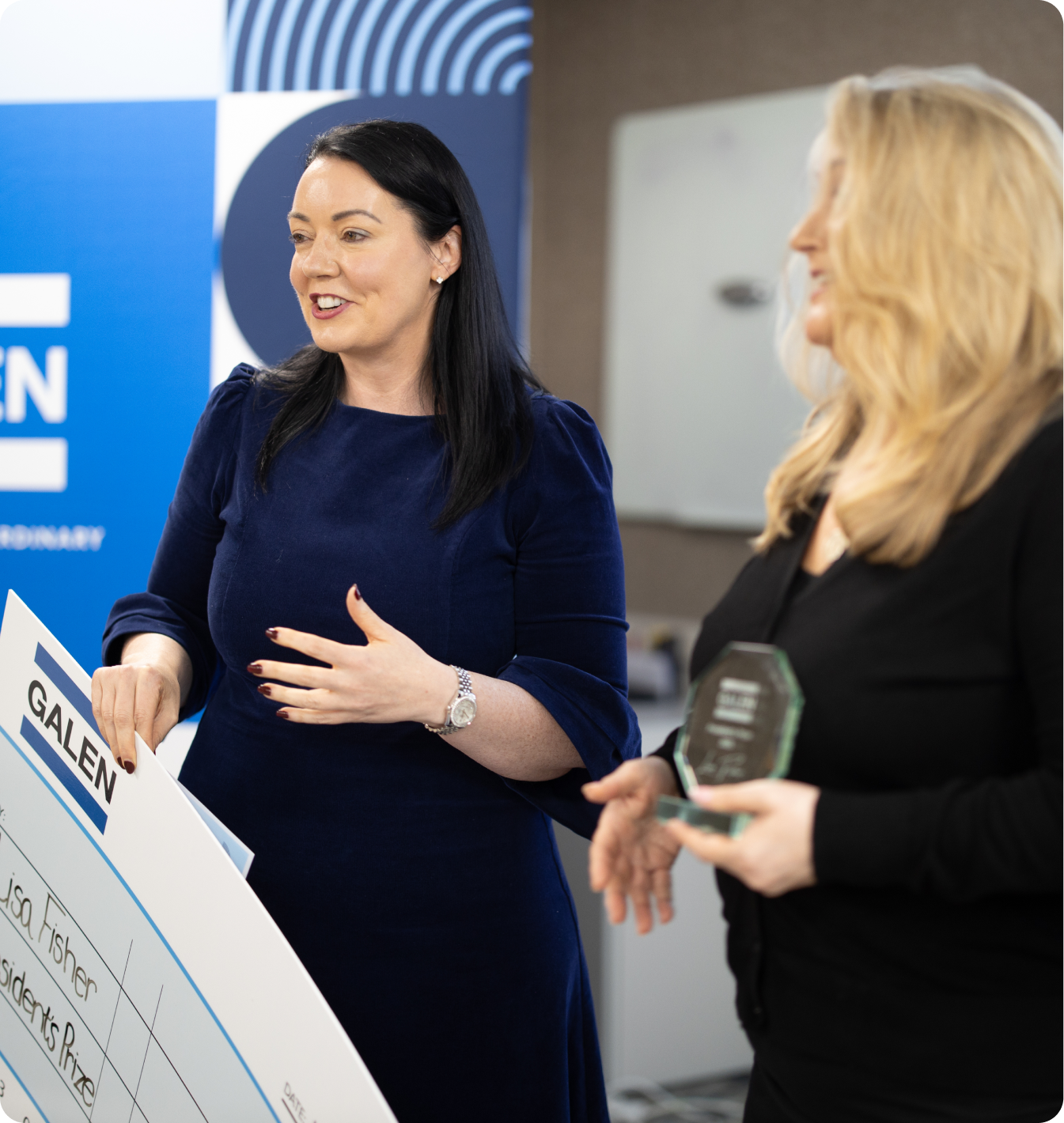 Two women at a Galen award ceremony, one holding a large cheque made out to Lisa Fisher for a President's Prize
