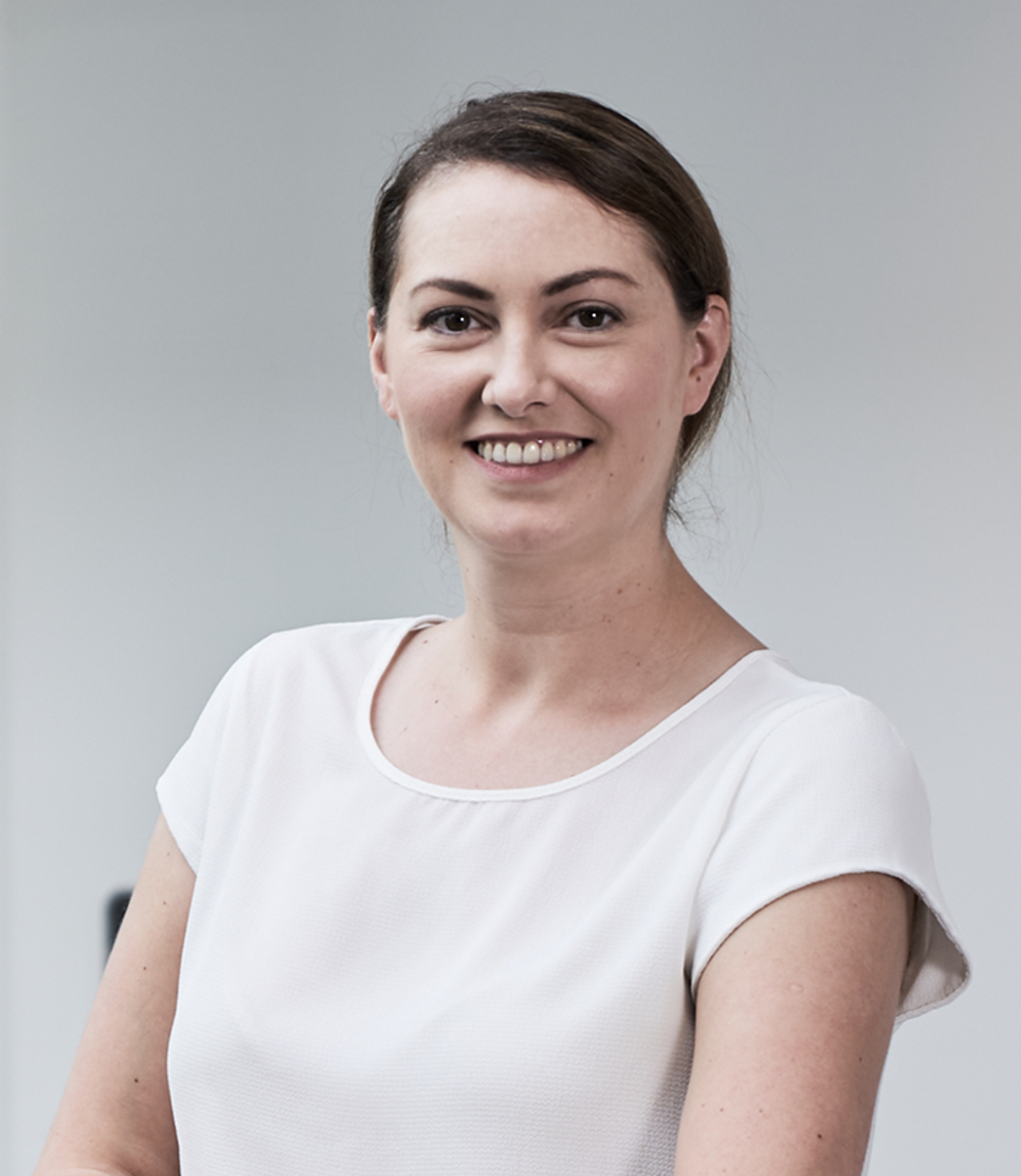 Sarah Dolan Ph.D. - smiling woman, white top, neutral background