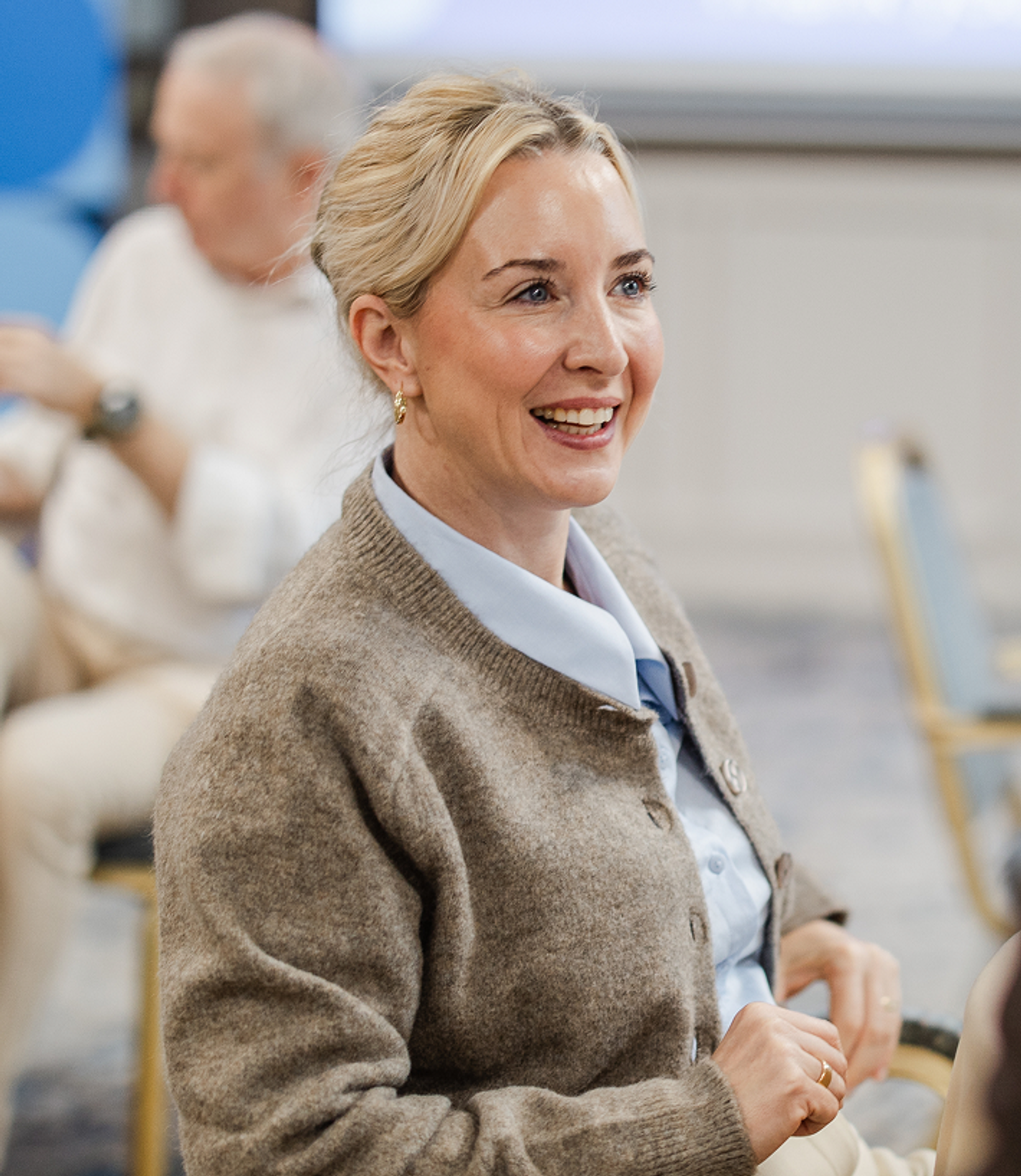 Anja Arentoft Jelle - smiling blonde woman, beige cardigan over patterned top