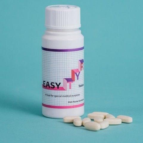 Flaske TYR Easy Tablets på en turkis baggrund med hvide tabletter spredt foran