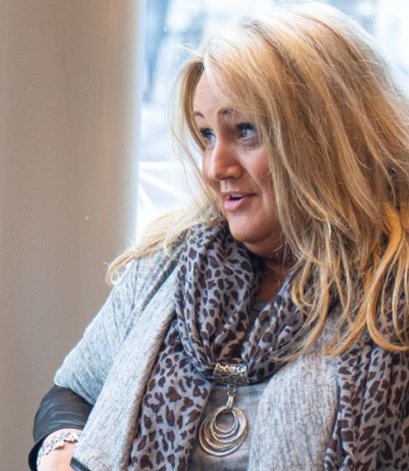 Lisa Fisher - woman with blonde wavy hair and scarf, smiling