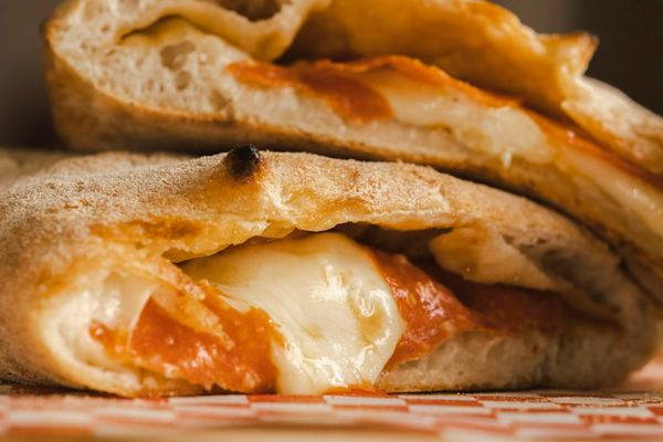 Aufgeschnittene Calzone mit Tomate und geschmolzenem Käse