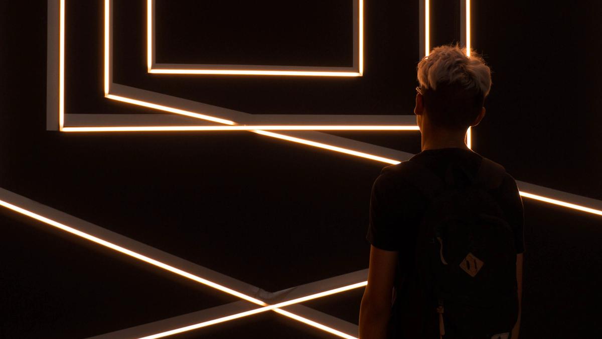 person standing in front of optical illusion wall