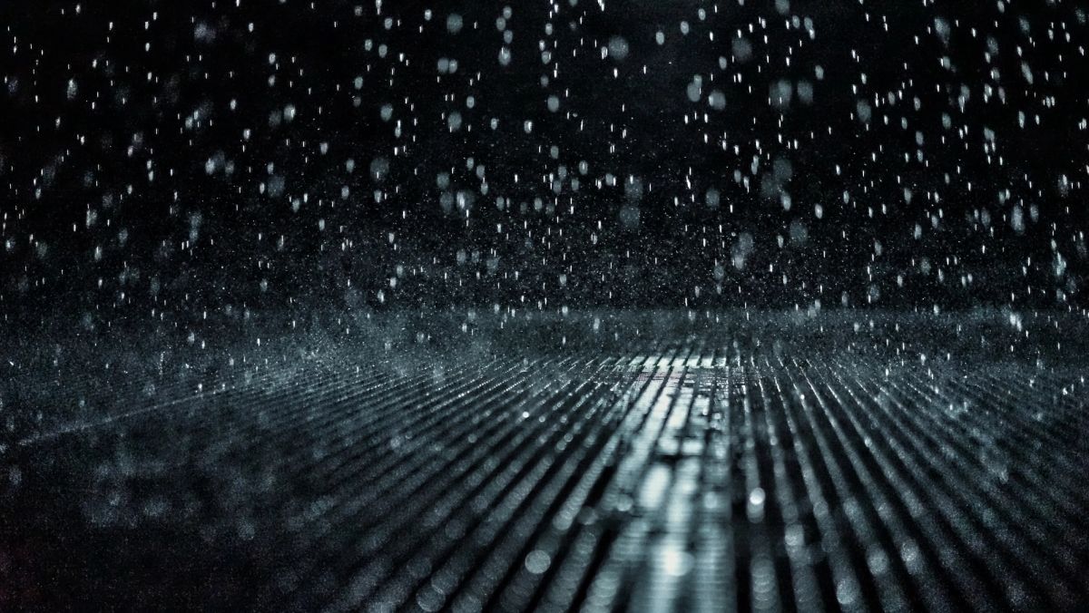 Photo a grate with raindrops falling on it.