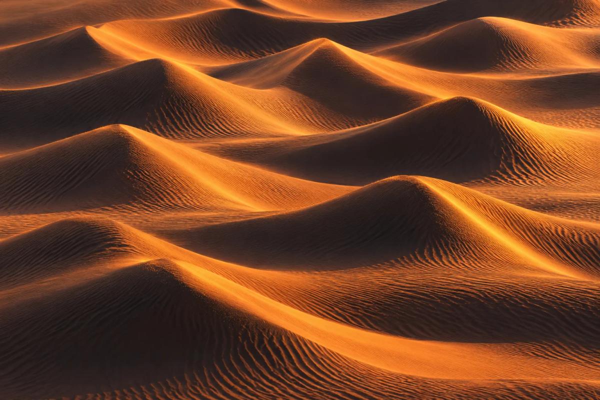 Sunset sand dunes forming repeating sound-wave ridges