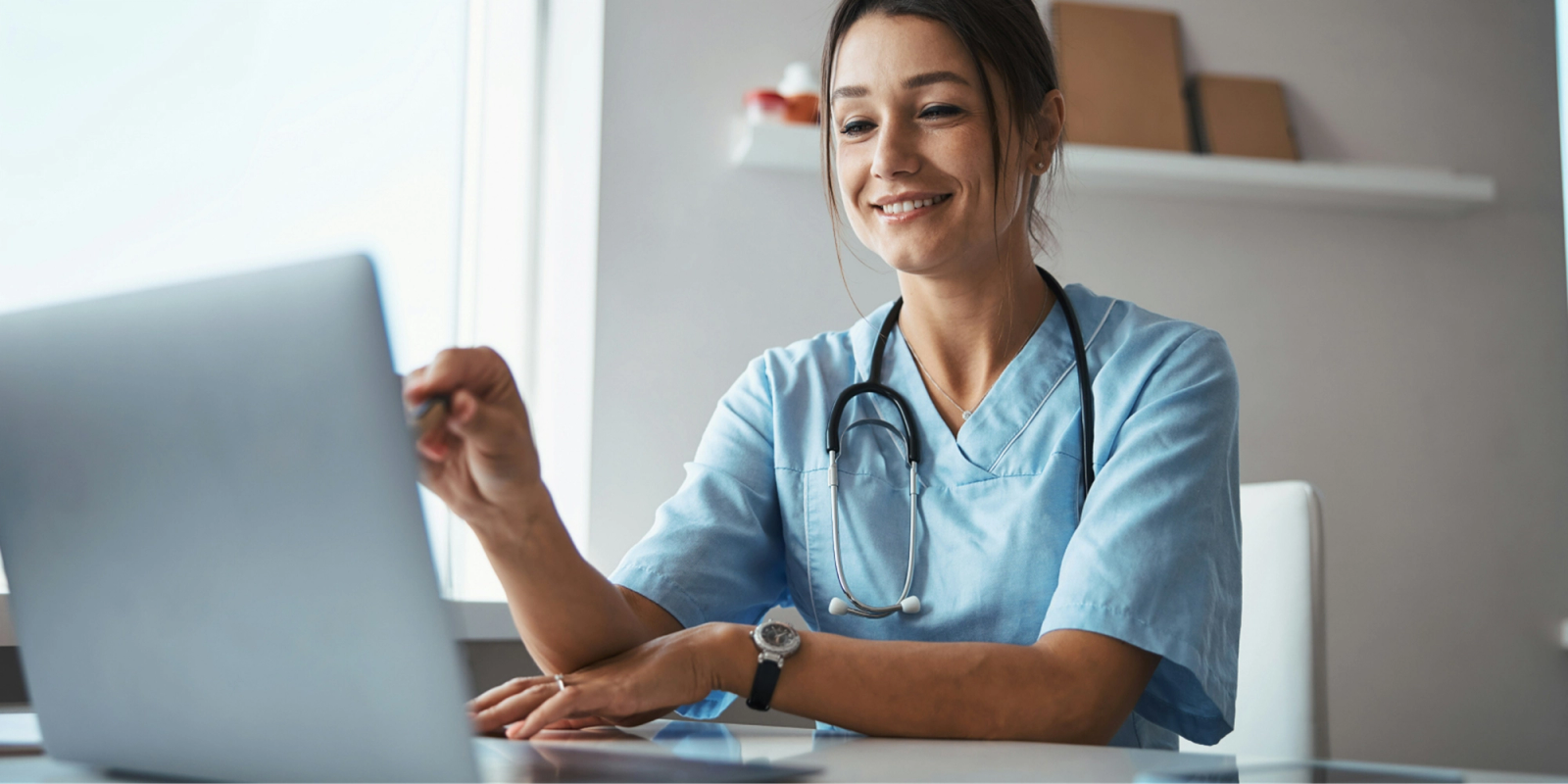 medical professional reviewing something on laptop