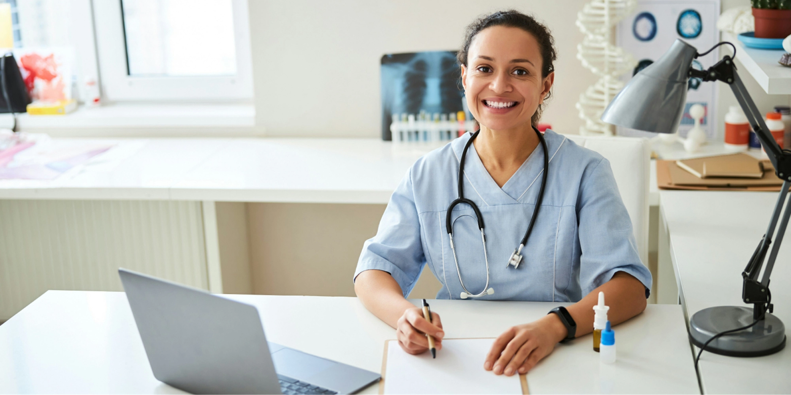 health care professional smiling at desk