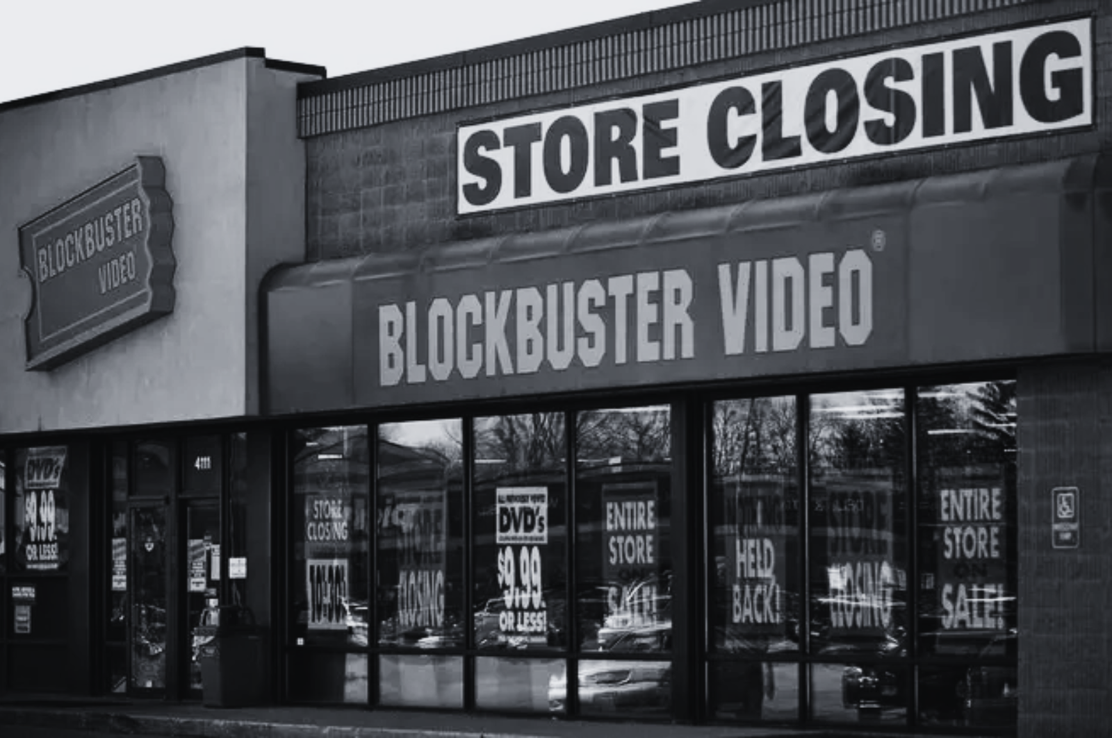 Black and white photo of a Blockbuster Video storefront with a Store Closing banner