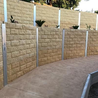 Sandstone block-finish retaining wall with steel posts and concrete capping at Adventure Park Geelong on the Bellarine