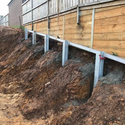 Staged hit-and-miss excavation with galvanised steel posts protecting a boundary fence during retaining wall construction in Geelong