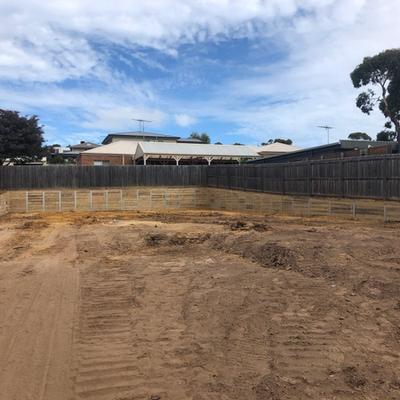 Timber sleeper retaining walls with steel posts wrapping a newly levelled backyard on a sloping Geelong block