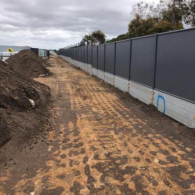 Colorbond fence on concrete sleeper plinth wall retaining a level change along an estate construction boundary