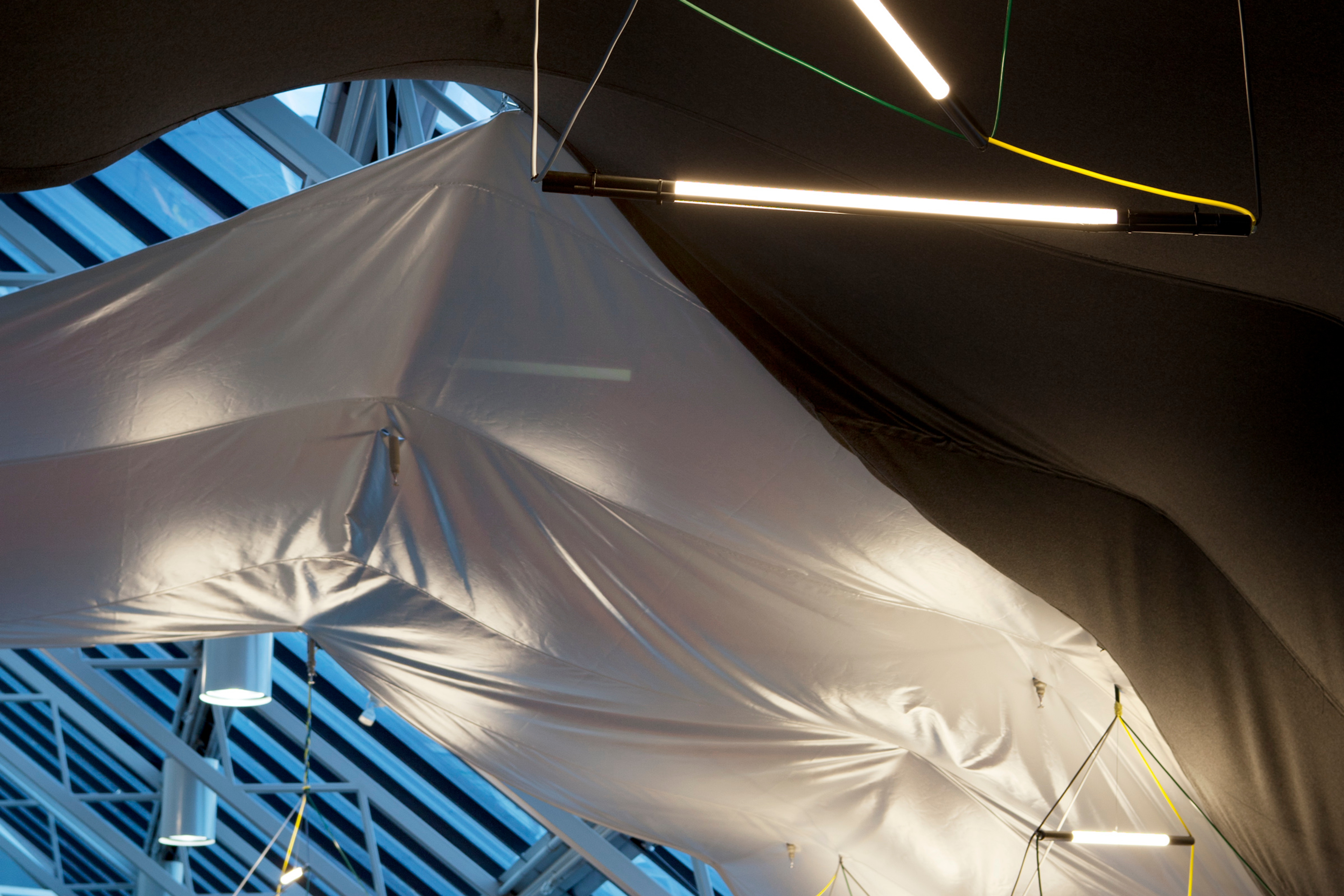 A suspended custom LED lighting system underneath a material ceiling treatment, designed by Foolscap for Clemenger BBDO.