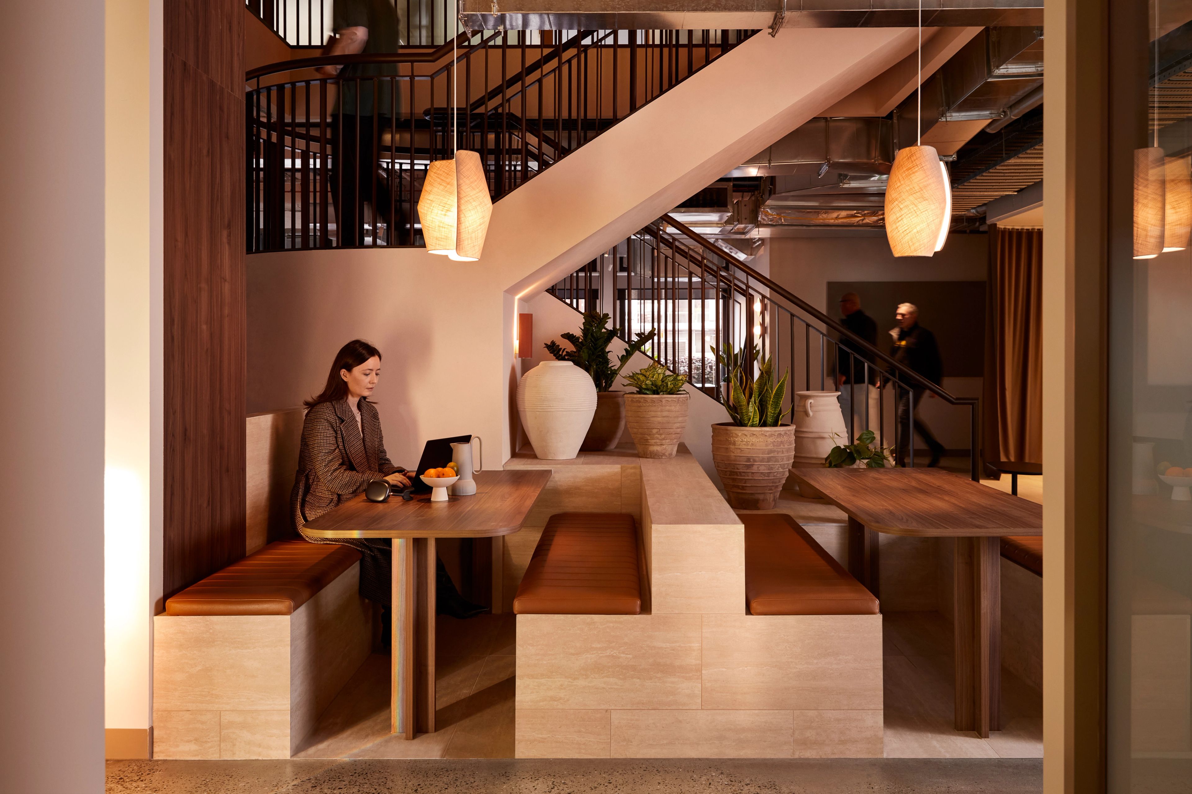 The breakout space at Forum Workspace, a premium coworking space designed by Foolscap. Banquette seating is tucked in around the connecting stair to optimise the floorplate. 