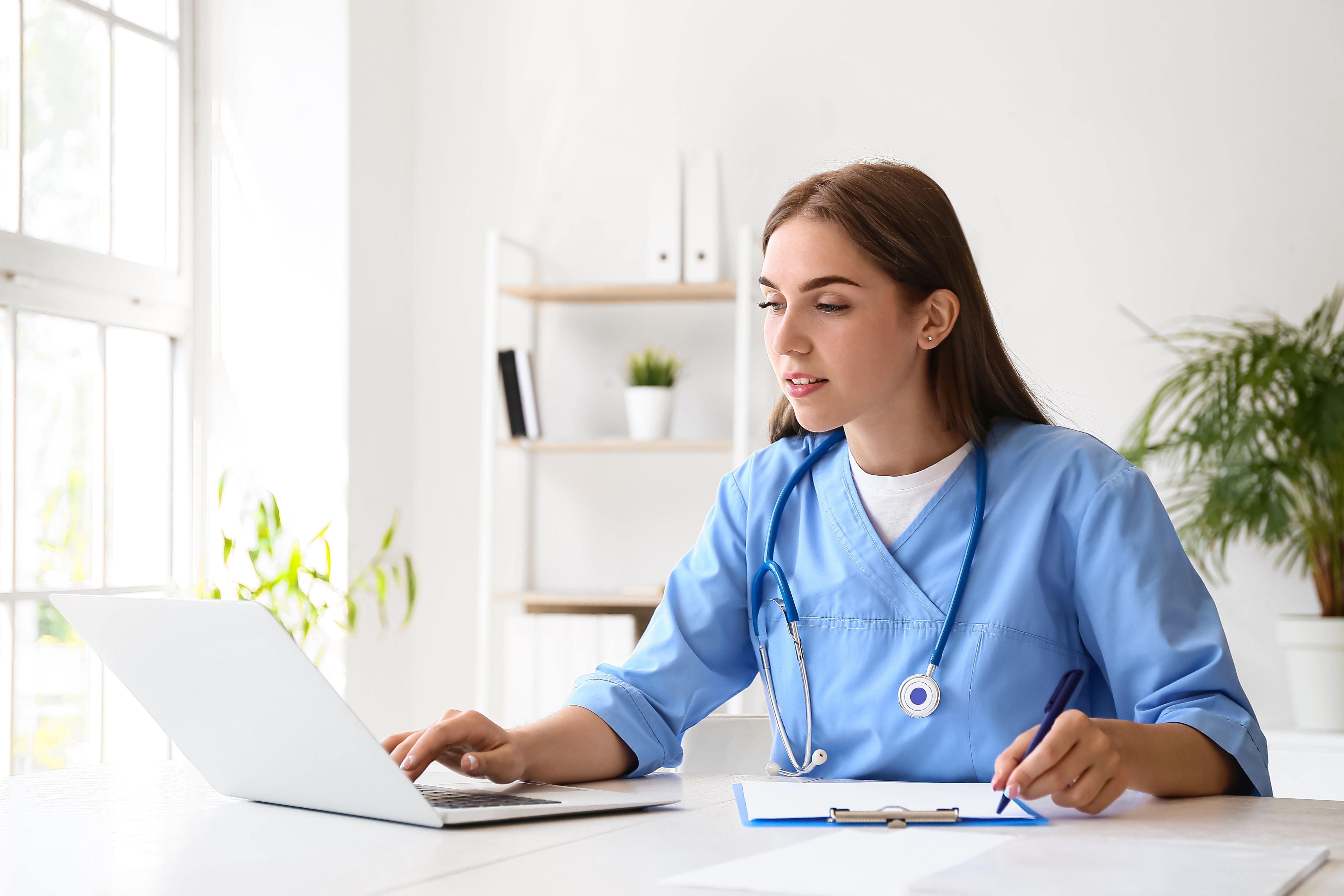 A physician writing a referral form for an infusion at violet health