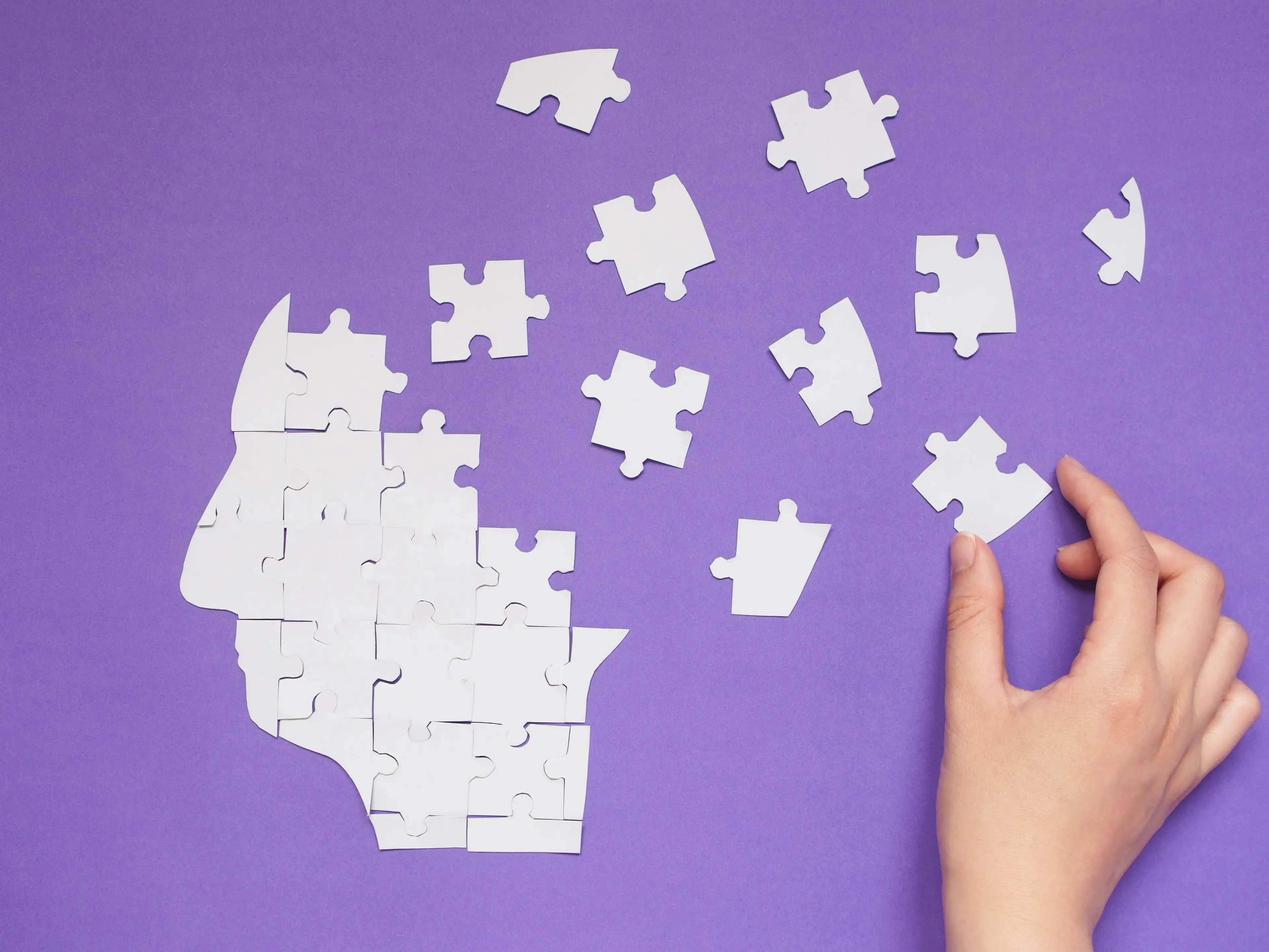 abstract alzheimer's puzzle being put together on a violet background
