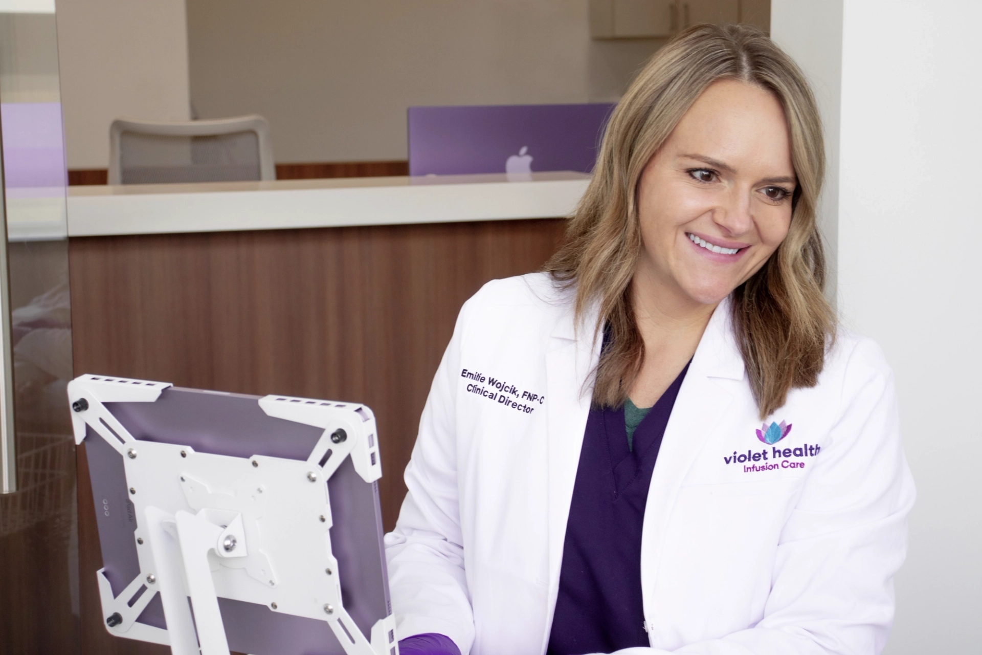 Emilie, our nurse practitioner, smiling at her station happy to assist a patient